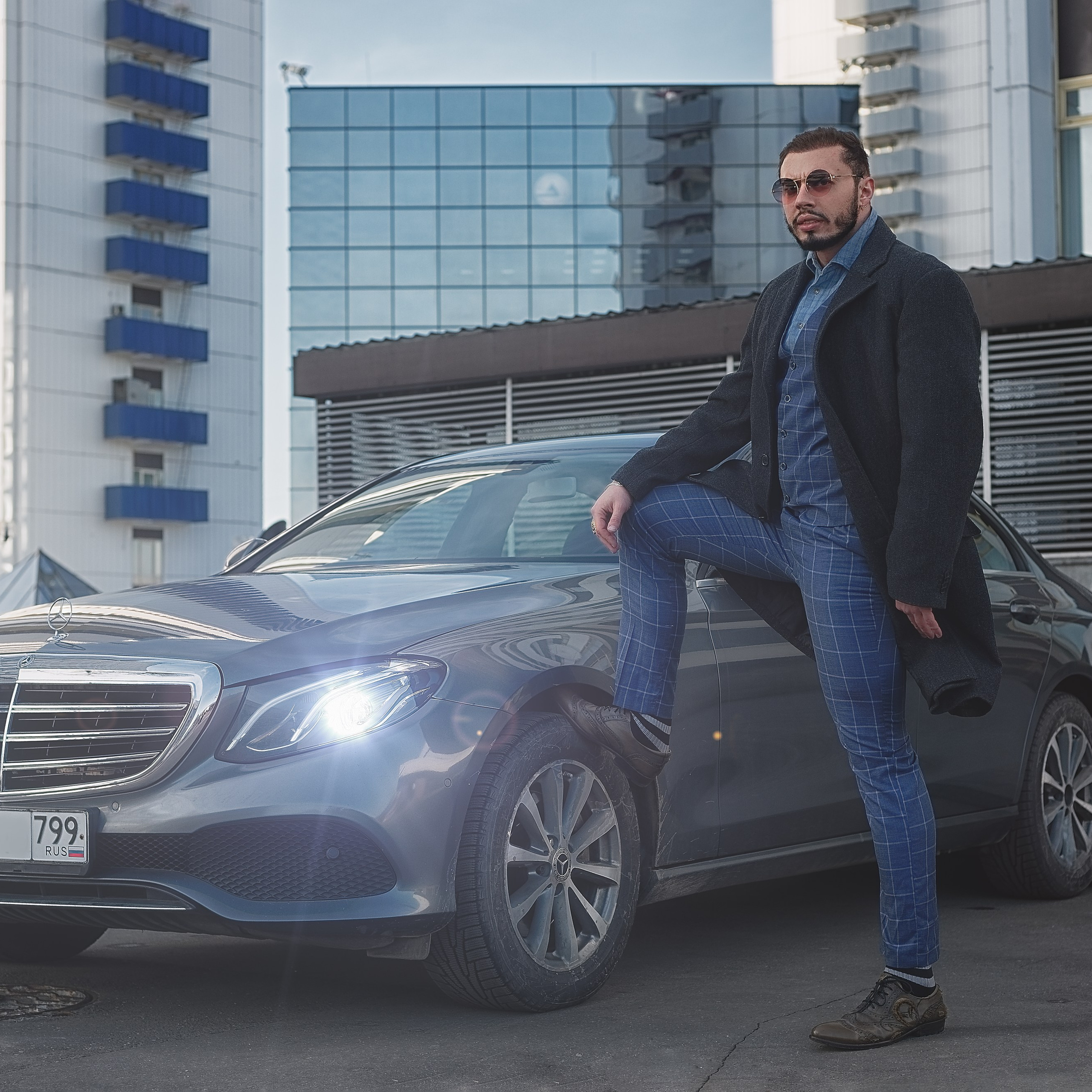 Мужчина в пальто стоит возле Мерседеса