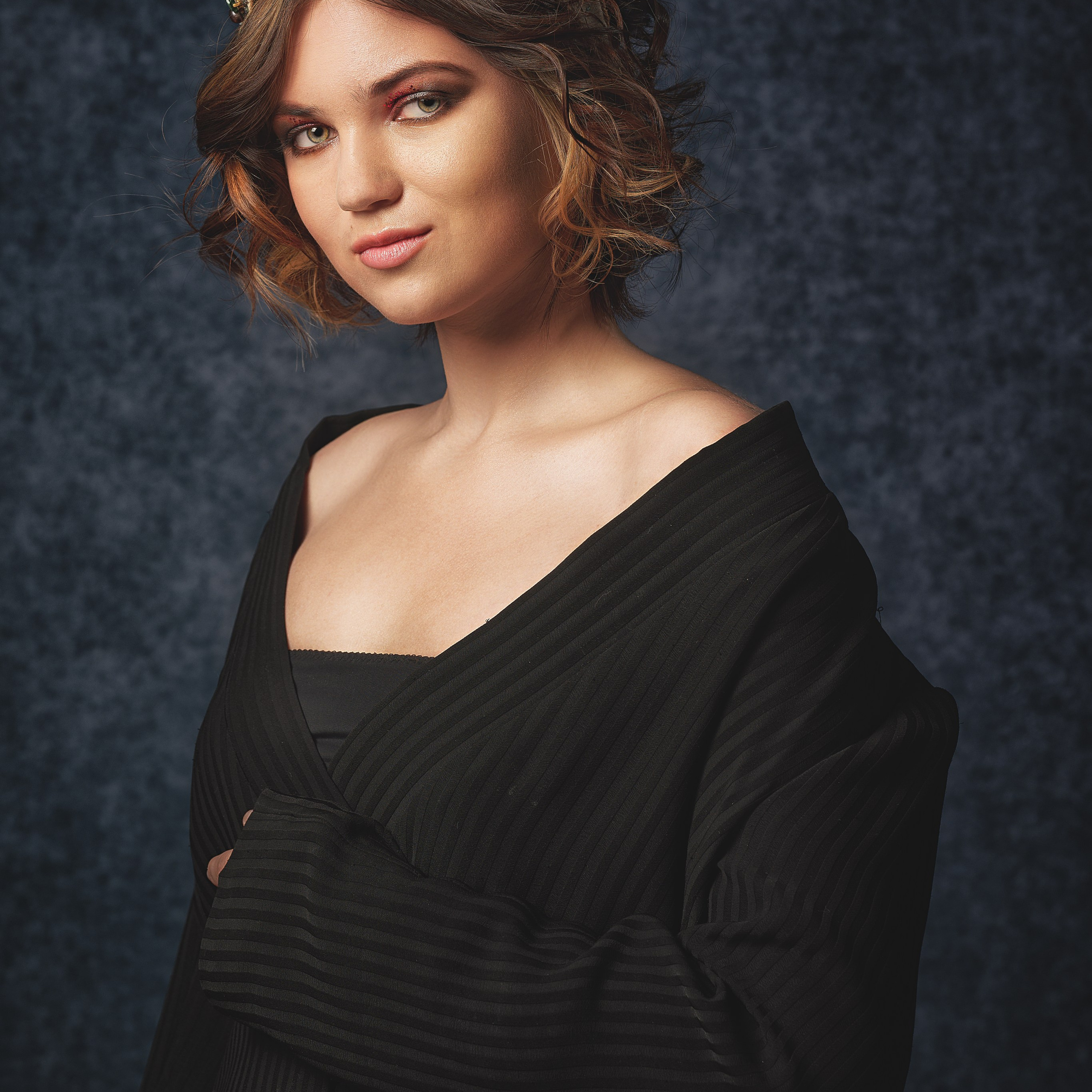 Девушка в золотой диадеме на синем фоне