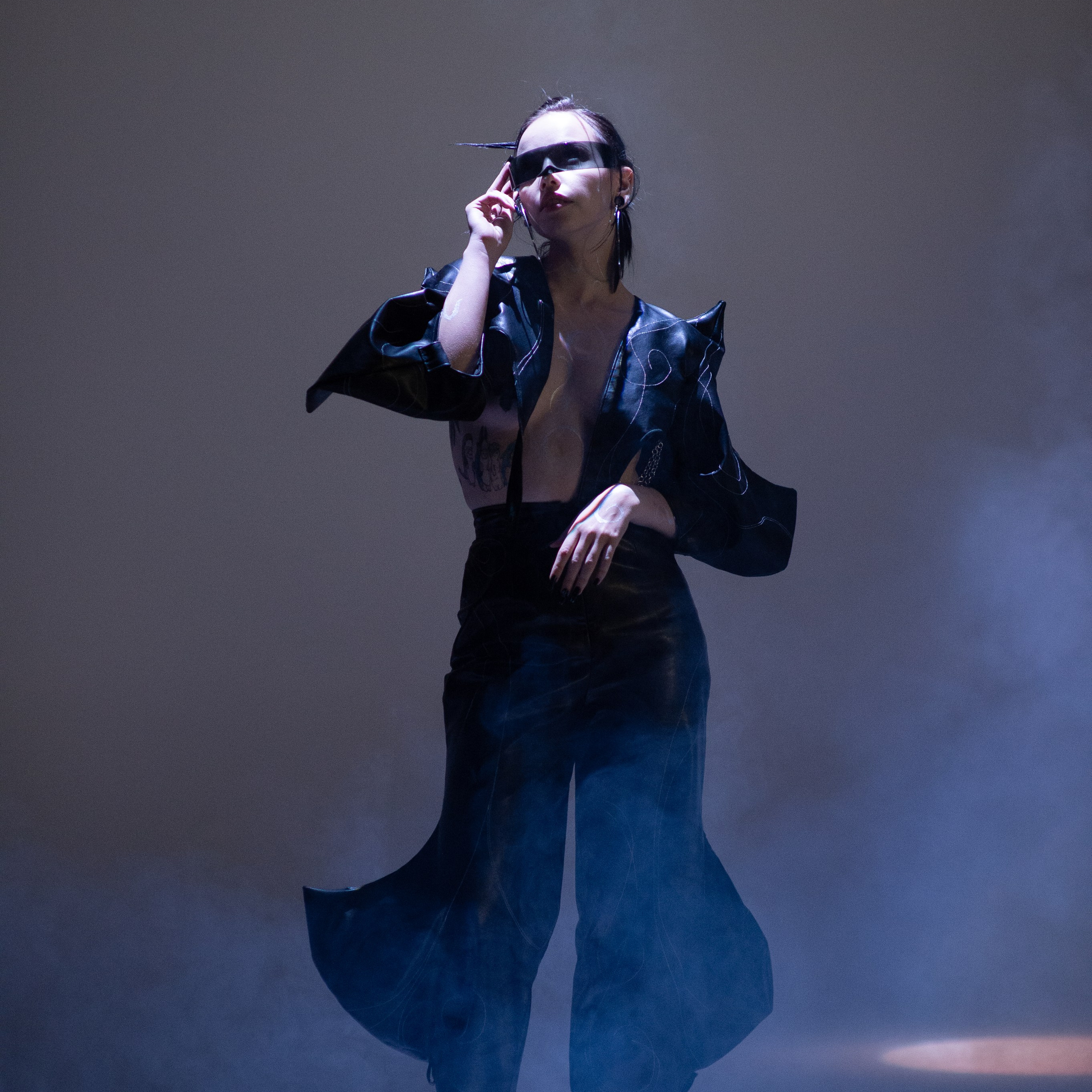 Девушка в темной одежде с открытым торсом