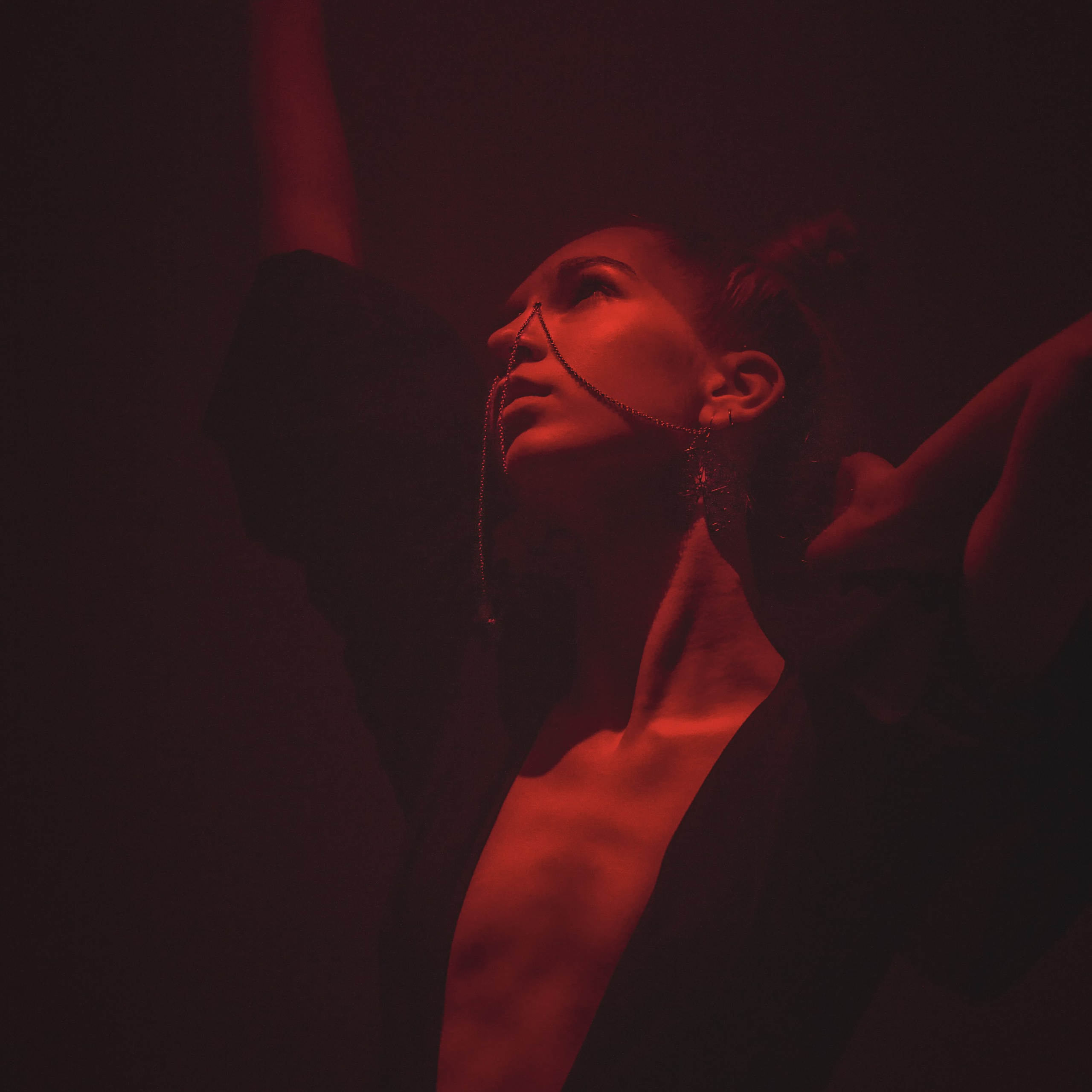 Девушка танцует под красным фонарем