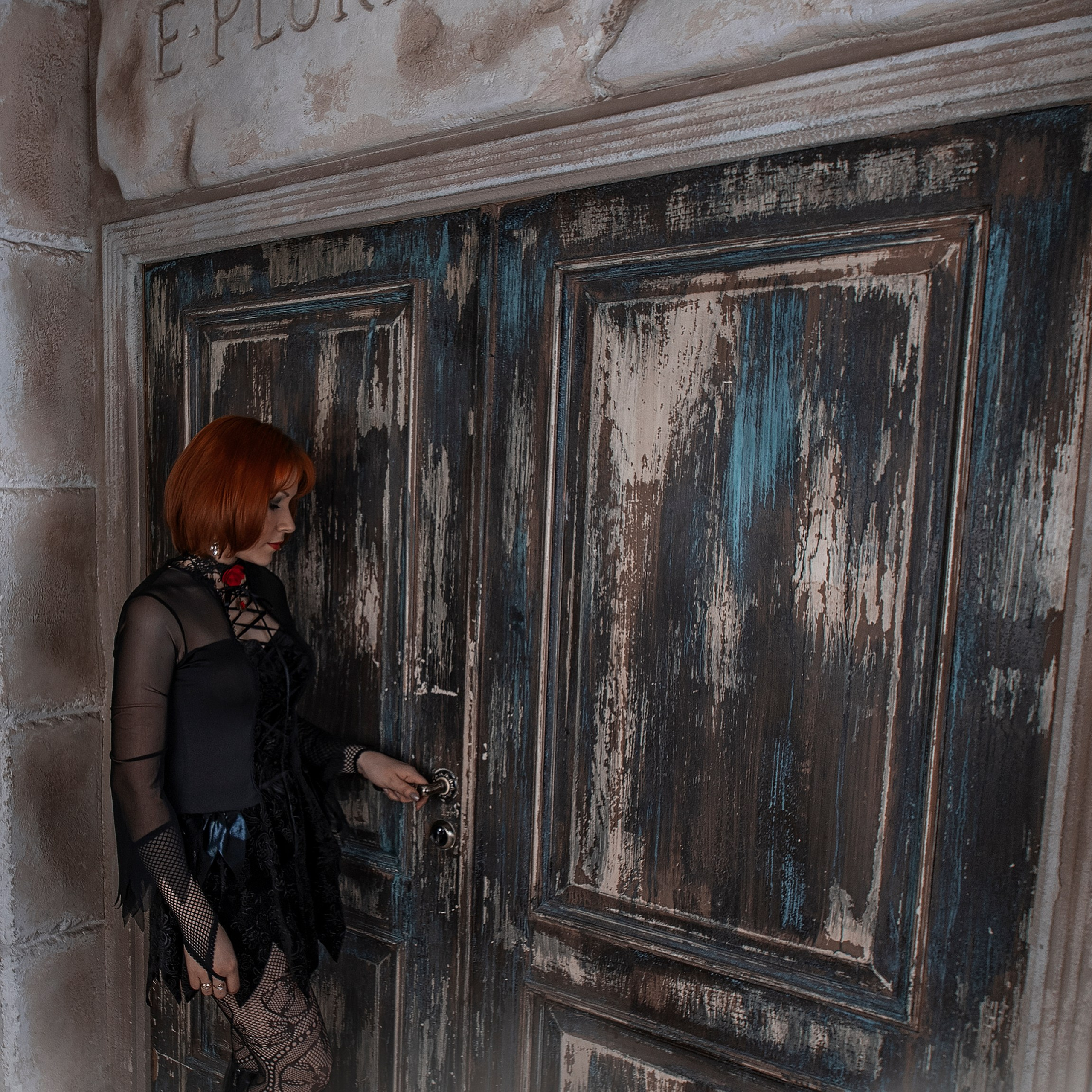 Рыжая девушка демон стоит у дверей