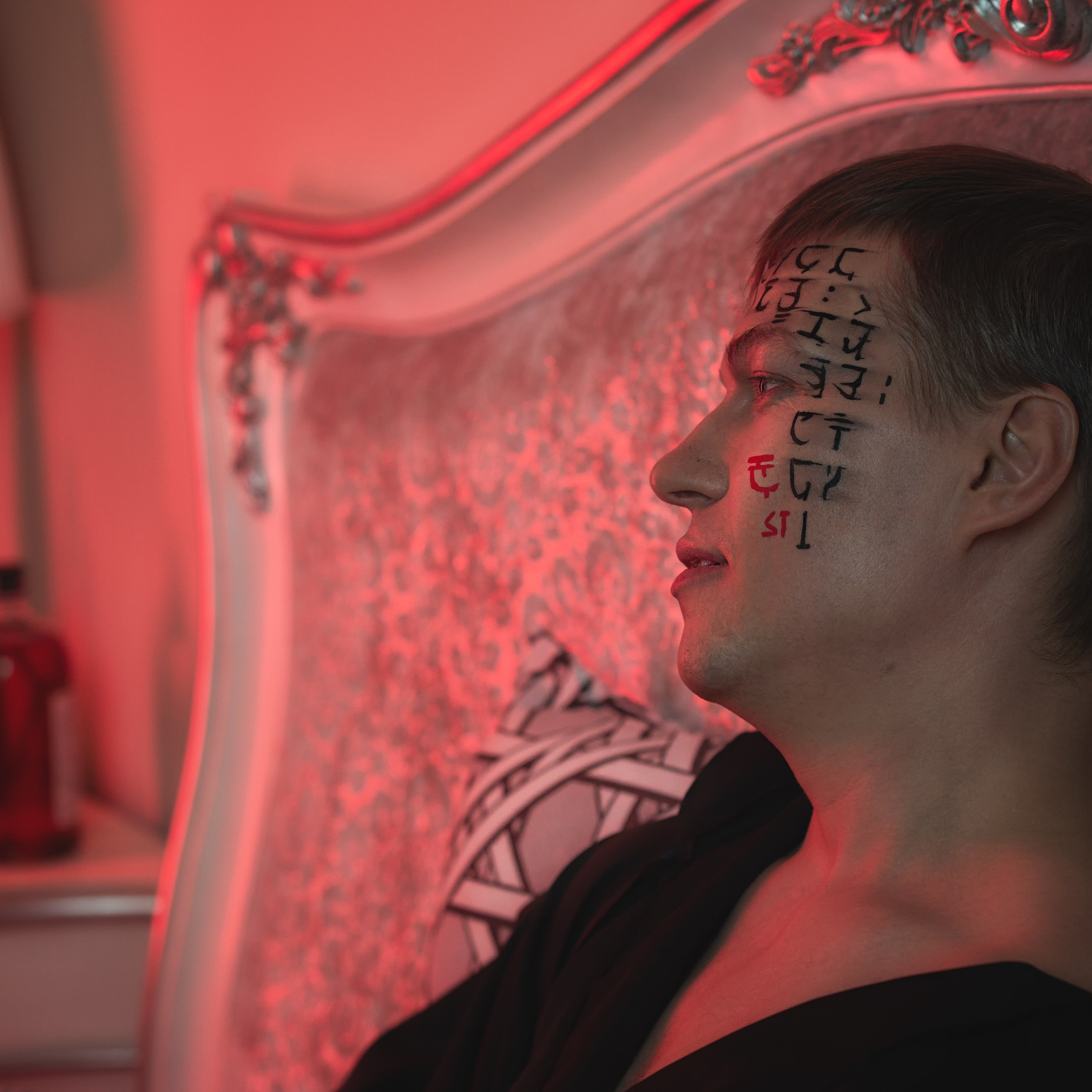 Мужчина с татуировками на лице смотрит в пустоту