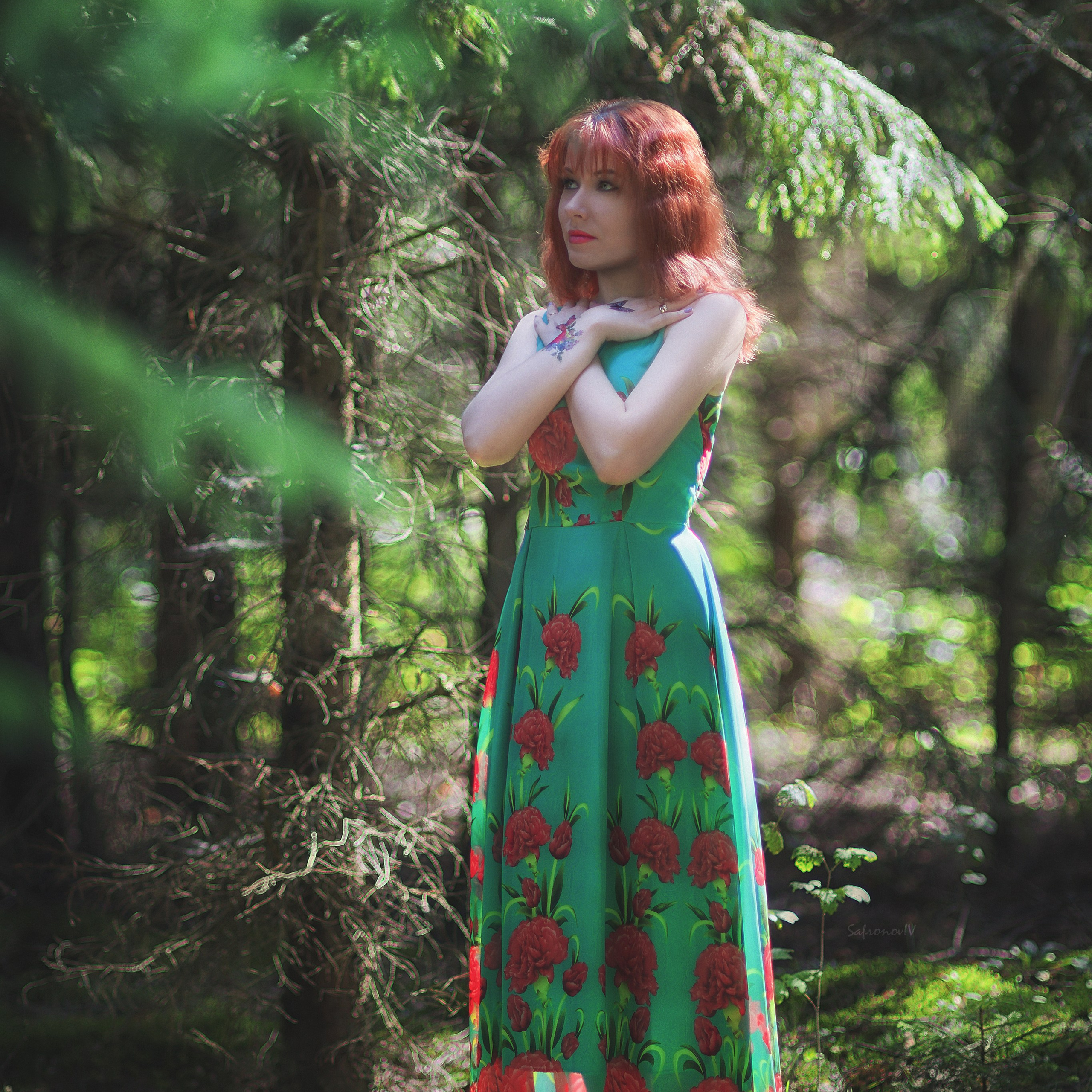 Девушка в зеленом платье и рыжими волосами в лесу