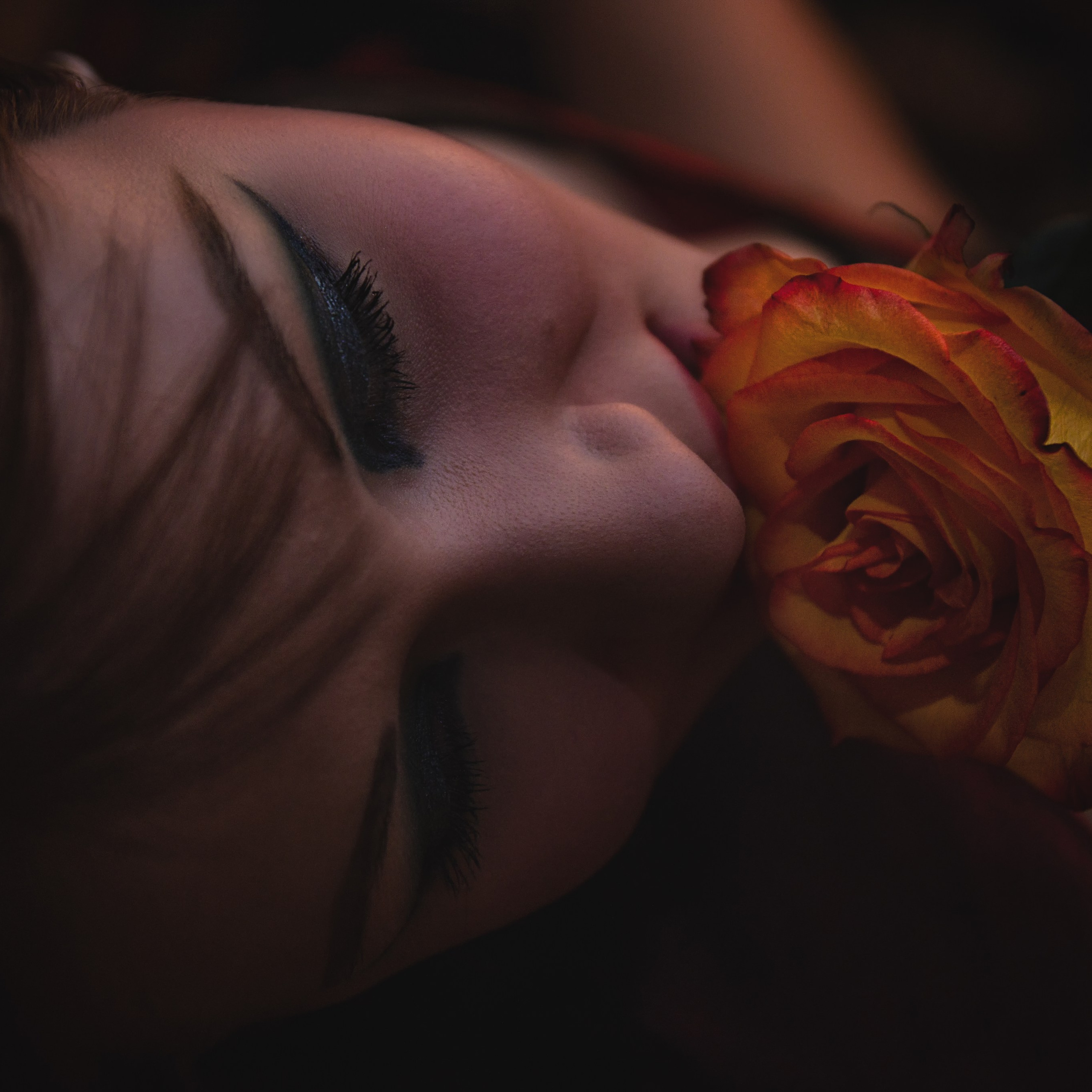 Лицо девушки, нюхает цветок