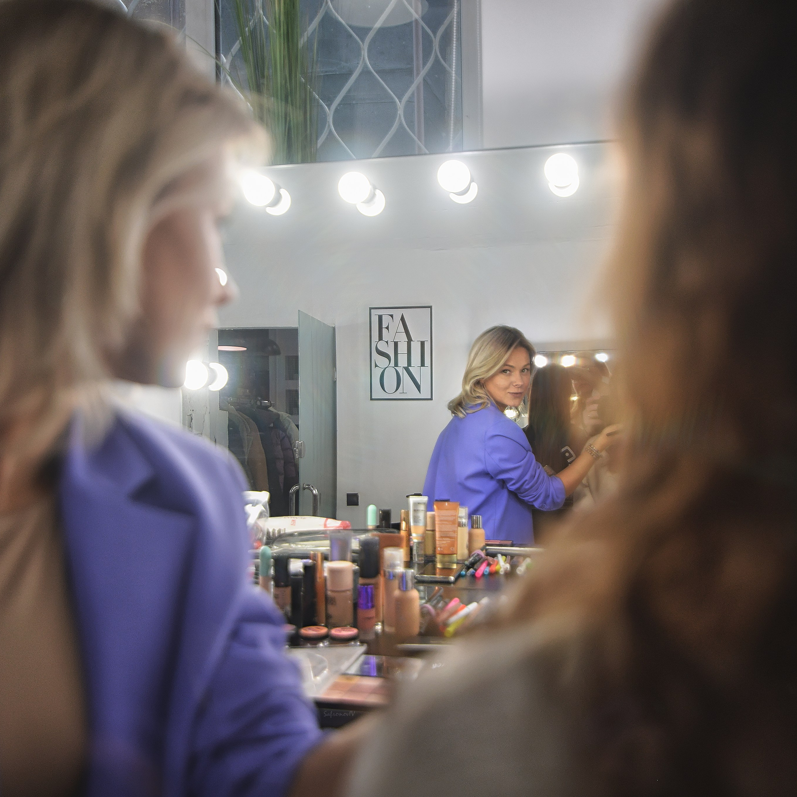 Визажист готовит образ и смотрит в зеркало