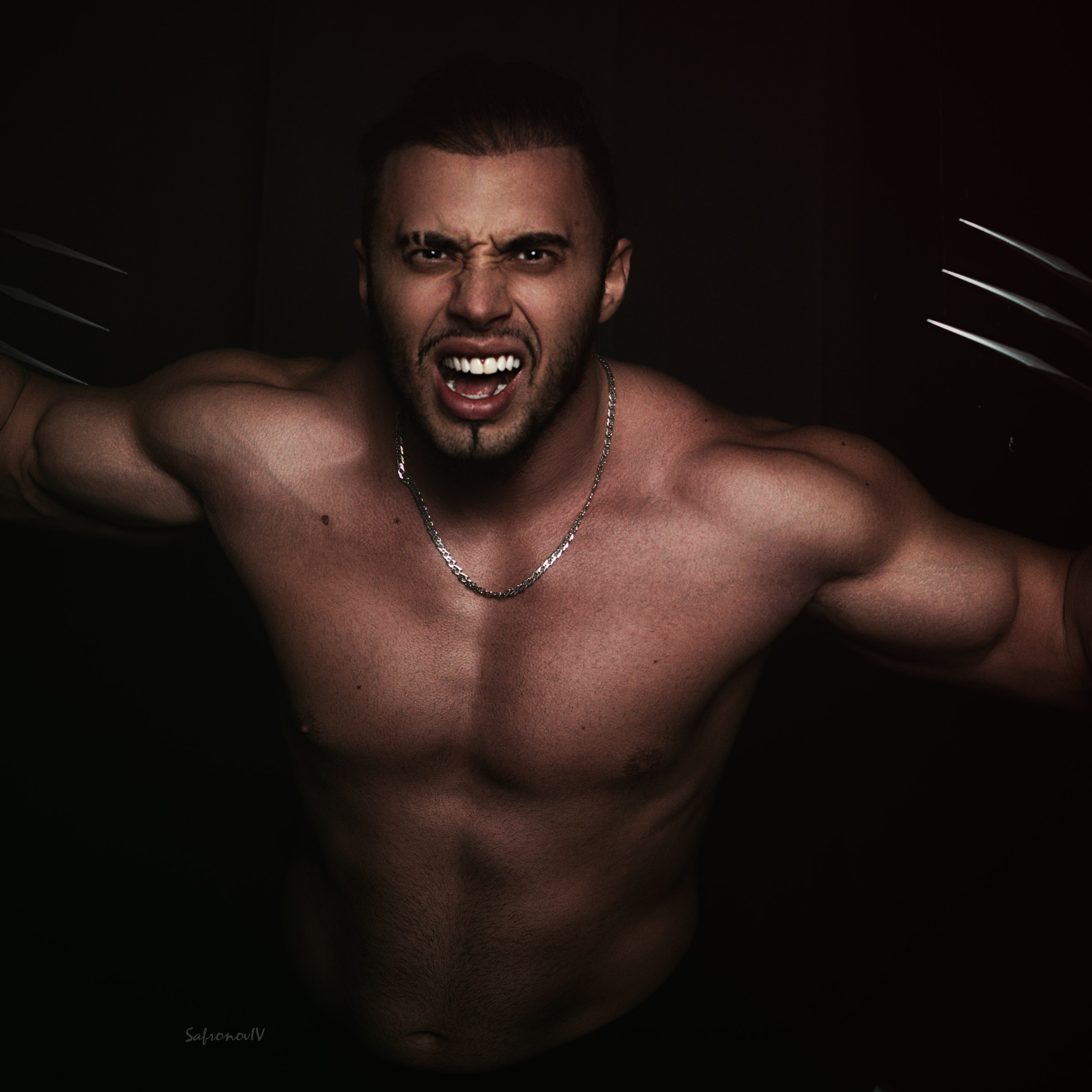 На изображении представлен мощный и драматичный портрет мужчины с обнажённым торсом, который демонстрирует впечатляющую физическую форму. Его лицо выражает ярость и агрессию, а металлические когти на руках добавляют образу фантастический и устрашающий элемент. Освещение подчёркивает рельеф мышц и создаёт эффектный контраст между светом и тенью, что делает снимок особенно выразительным. Ключевые слова: портретный фотограф в Москве, фотограф Сафронов Иван, художественная фотография, драматический портрет, мускулистый мужчина, когти, свет и тень.