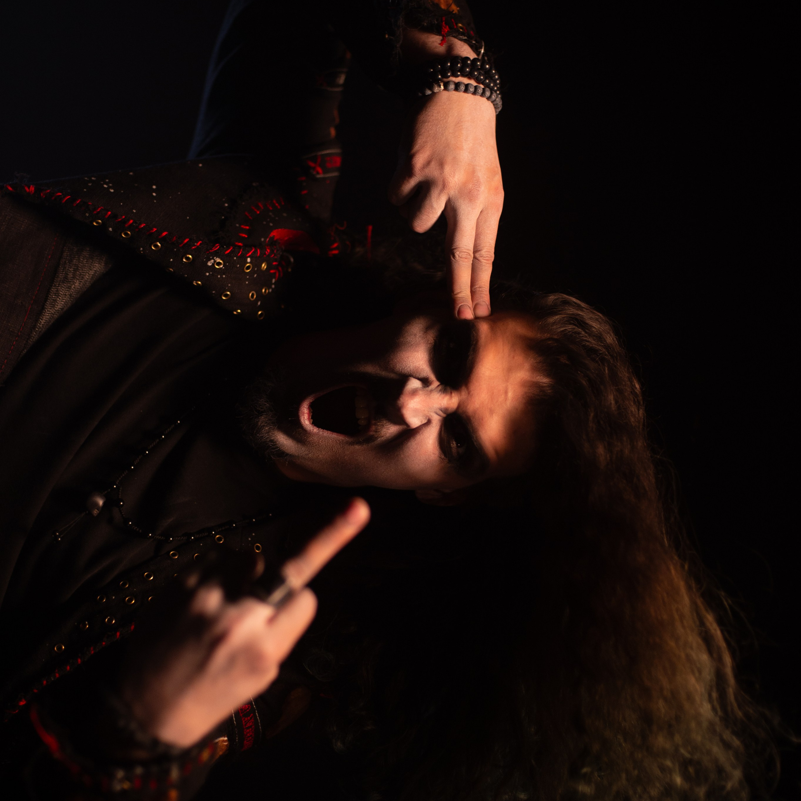 Мужчина с длинными волосами показывает всем средний палец