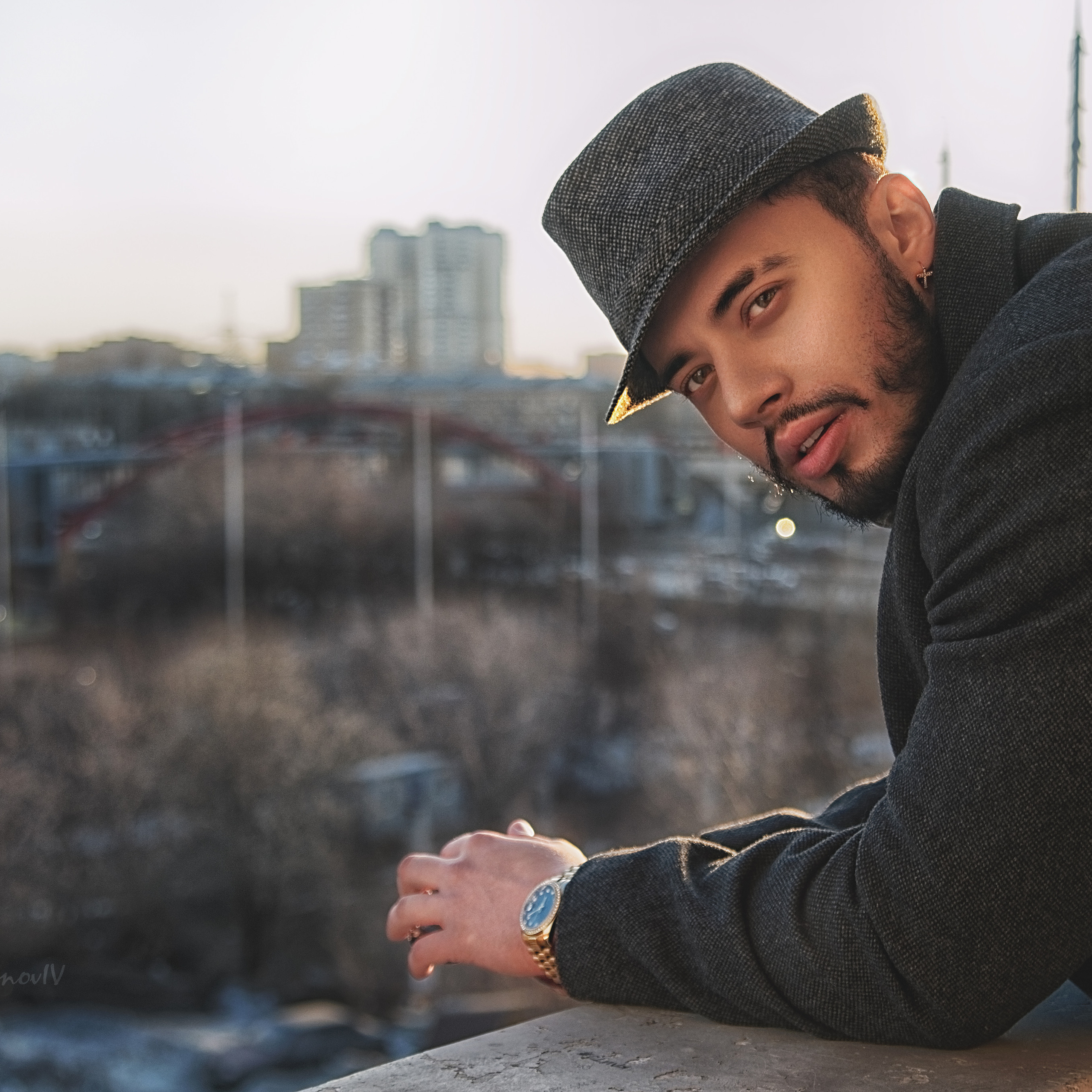 Бородатый мужчина в шляпе смотрит на город