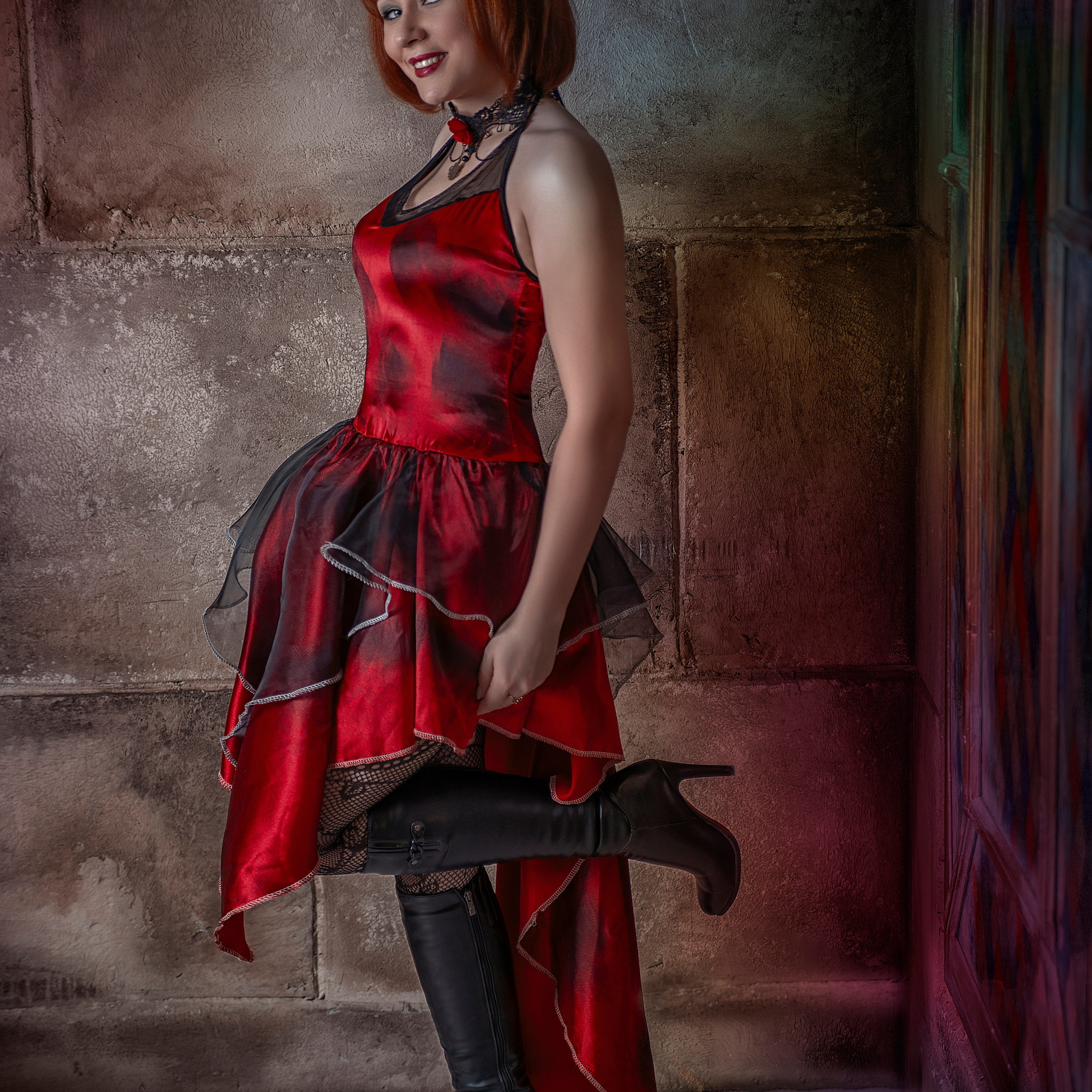 Девушка в красном платье стоит в углу замка