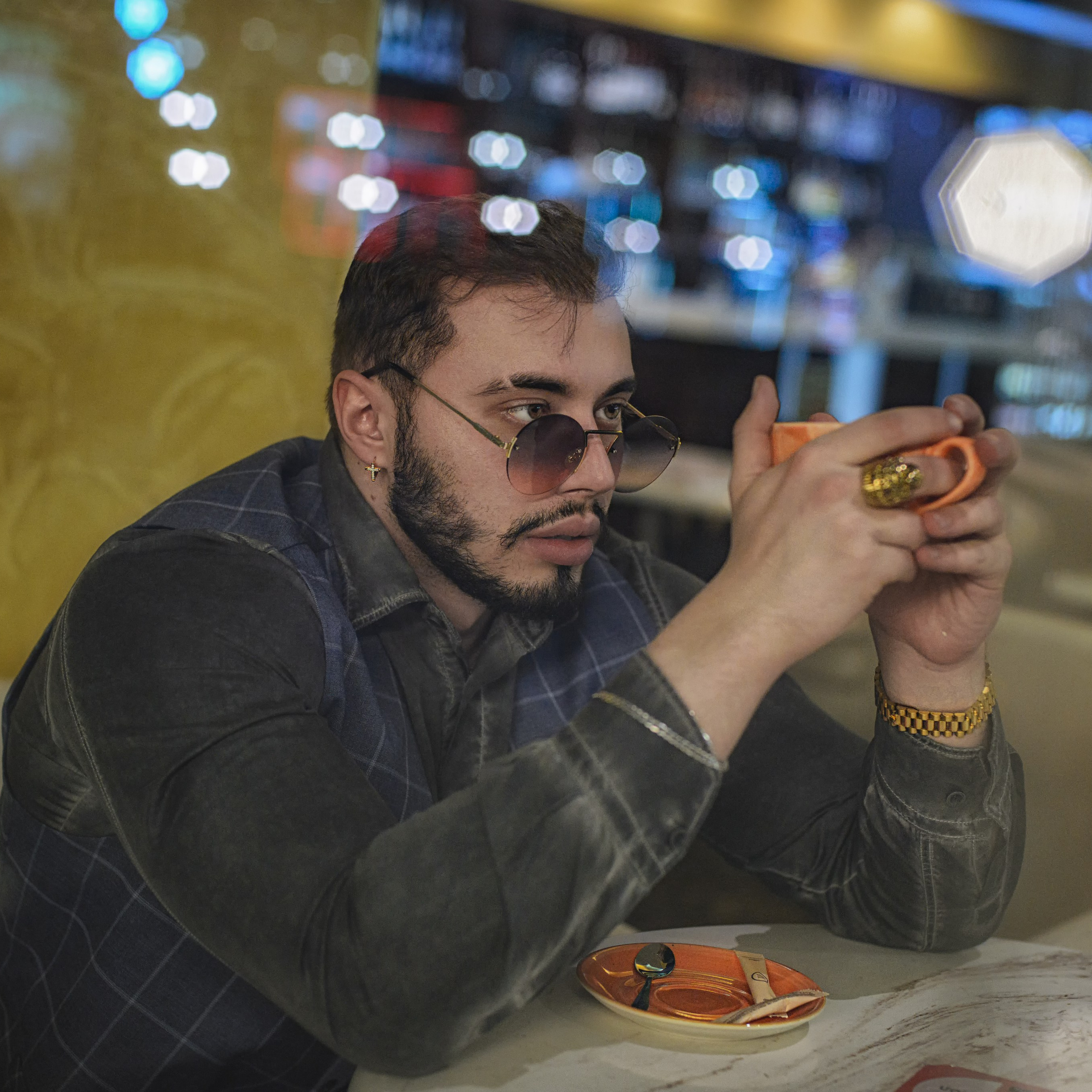 Мужчина в темных очках сидит в кафе пьет кофе