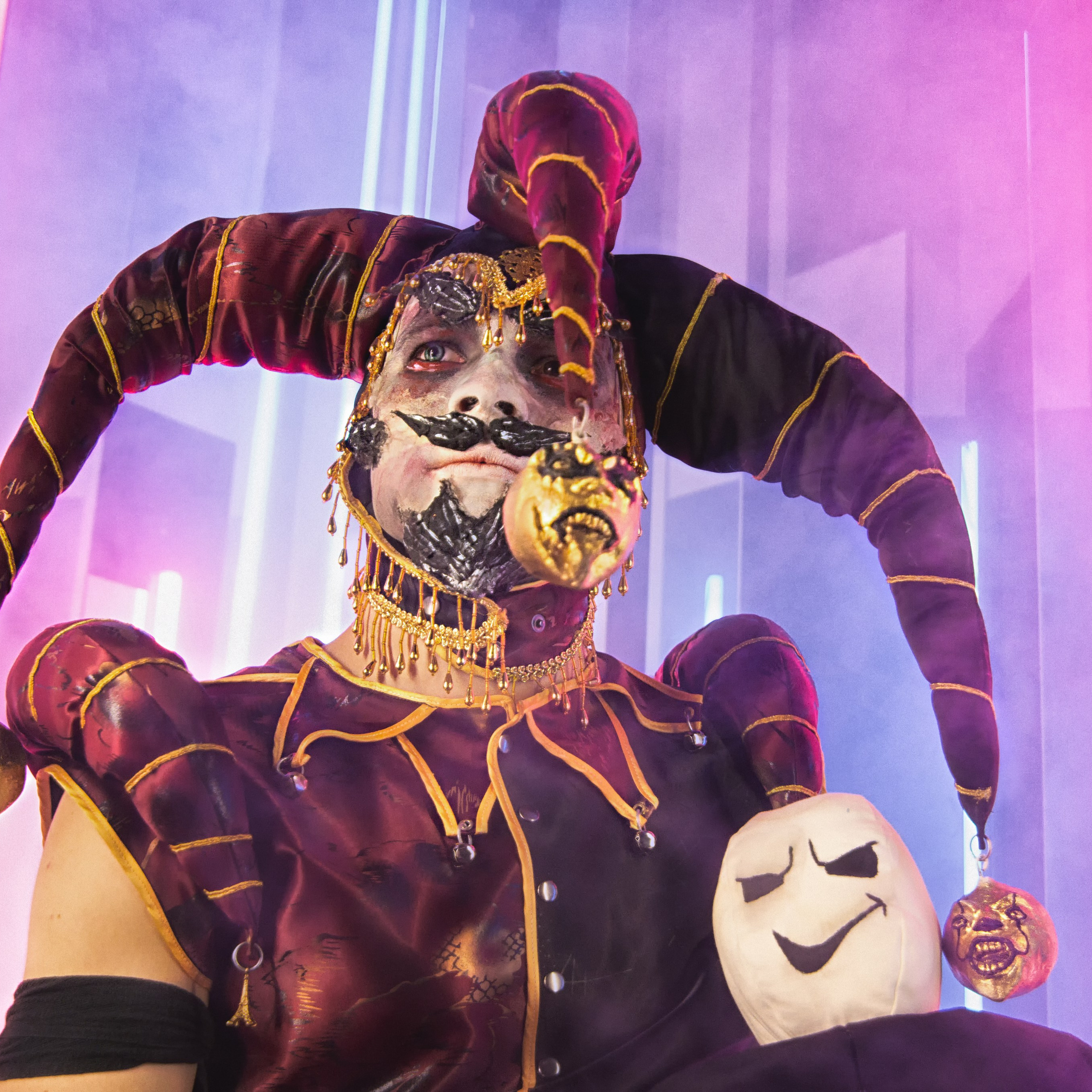 Шут сидит с куклой в руках