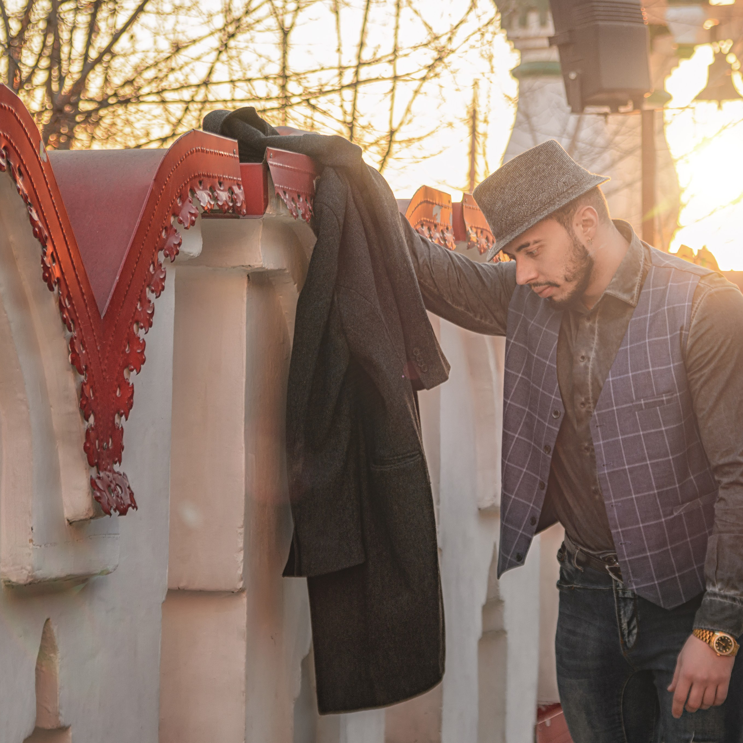 мужчины отдыхает у забора на закате дня