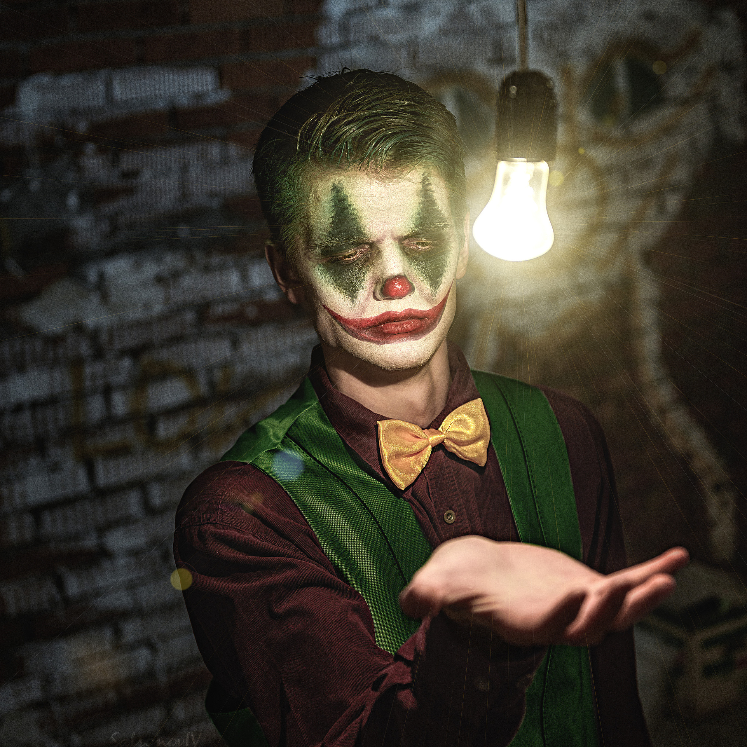 Джокер держит руку под лампой