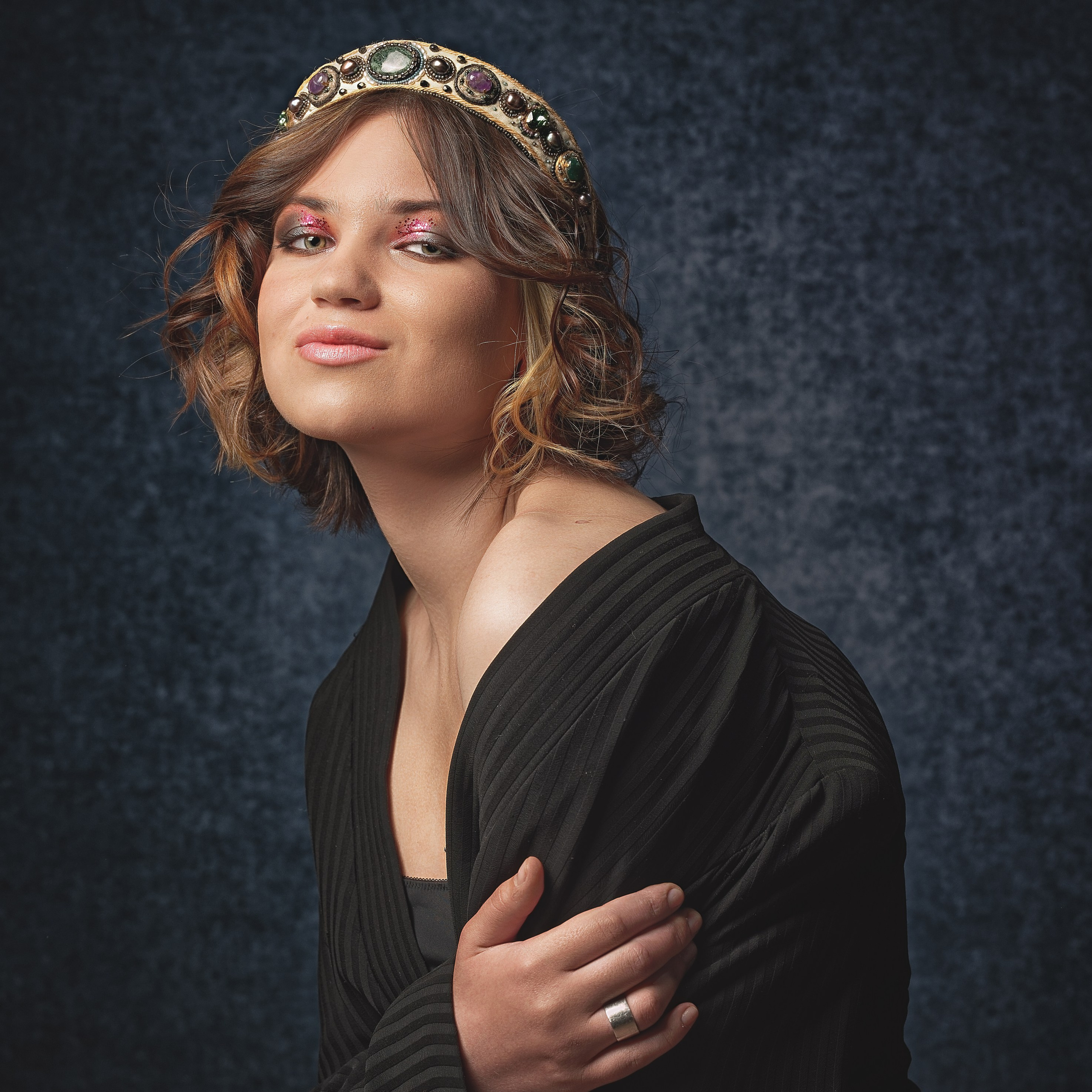 Девушка в черном джемпере обнимает себя