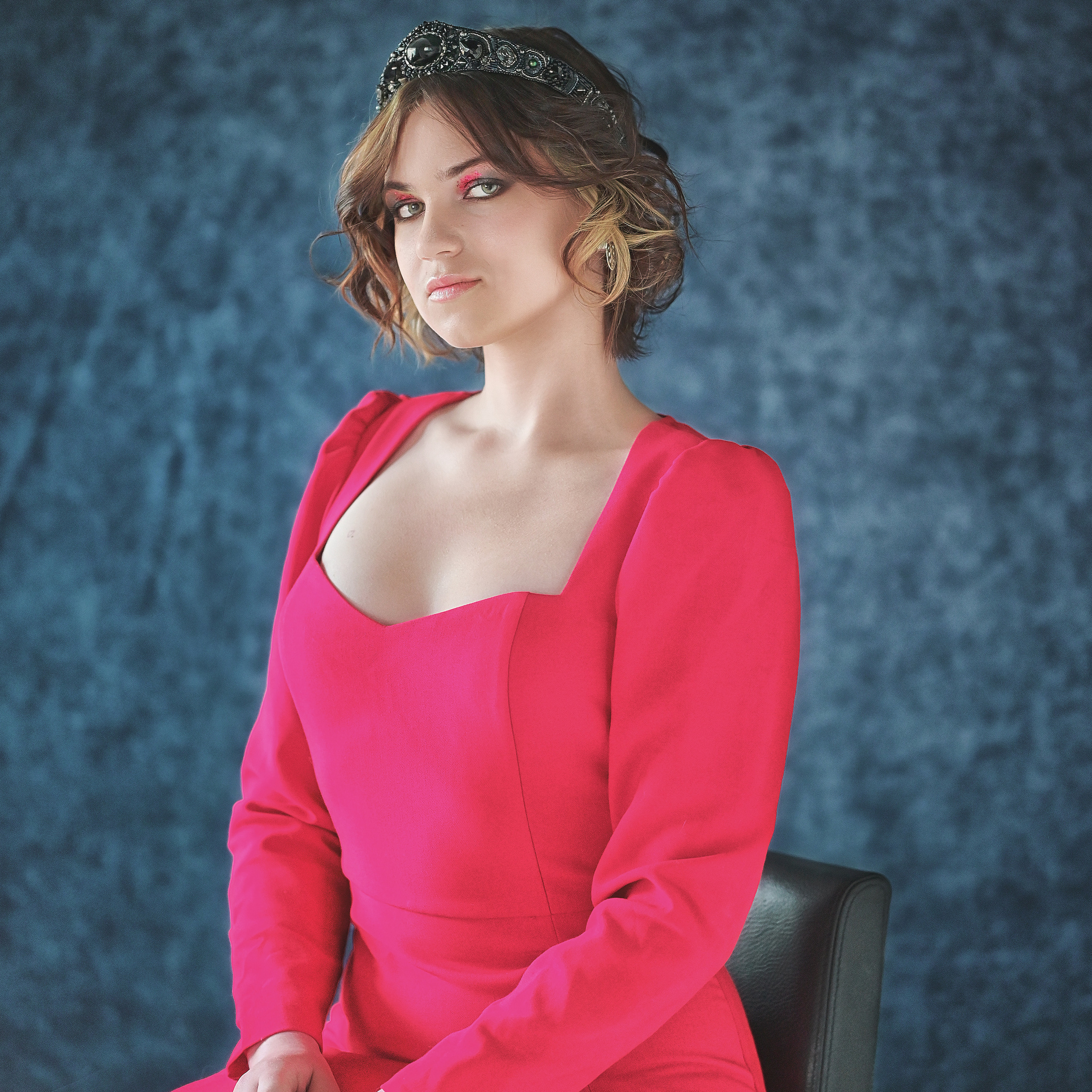 Девушка в красном сидит на синем фоне