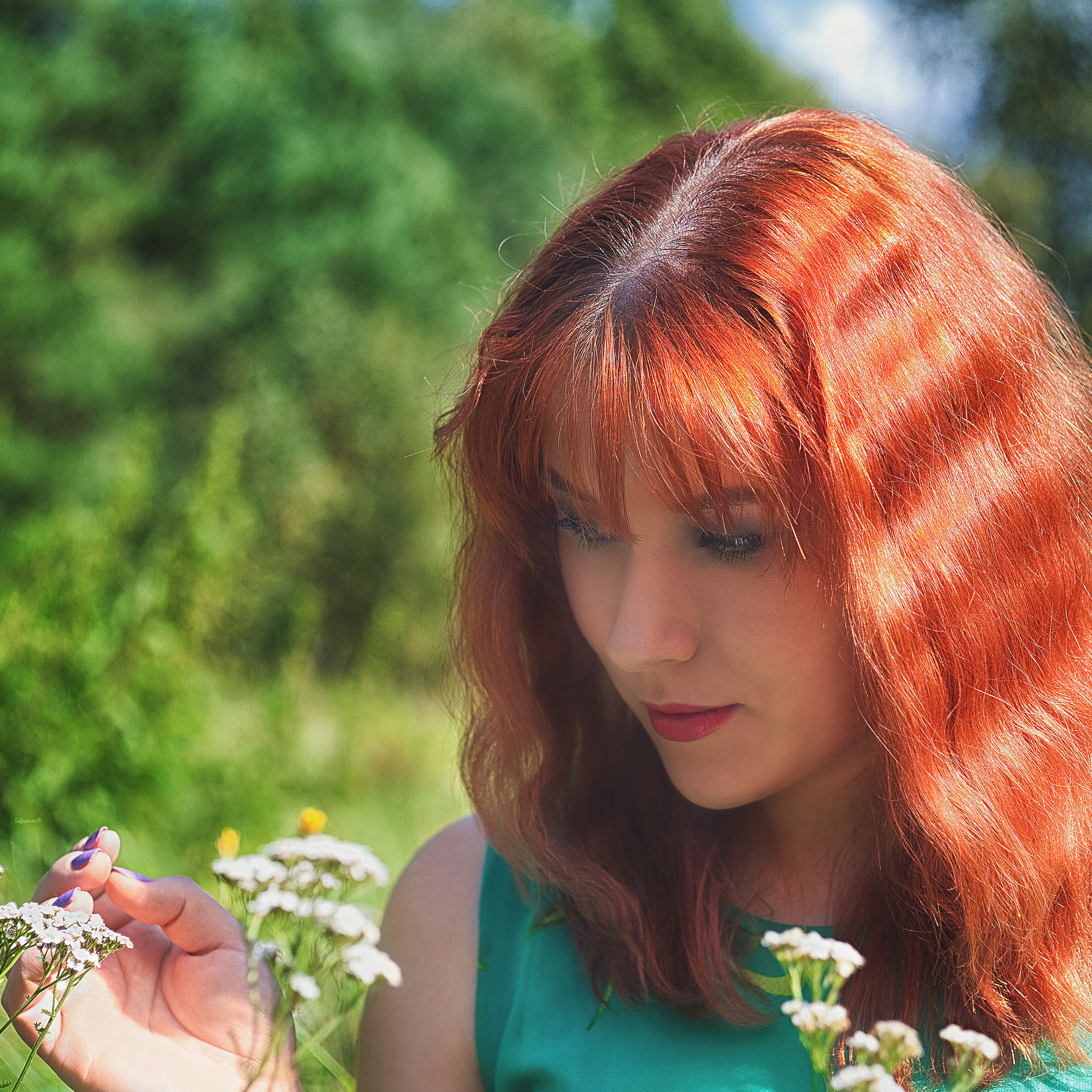 Девушка тянется понюхать цветы