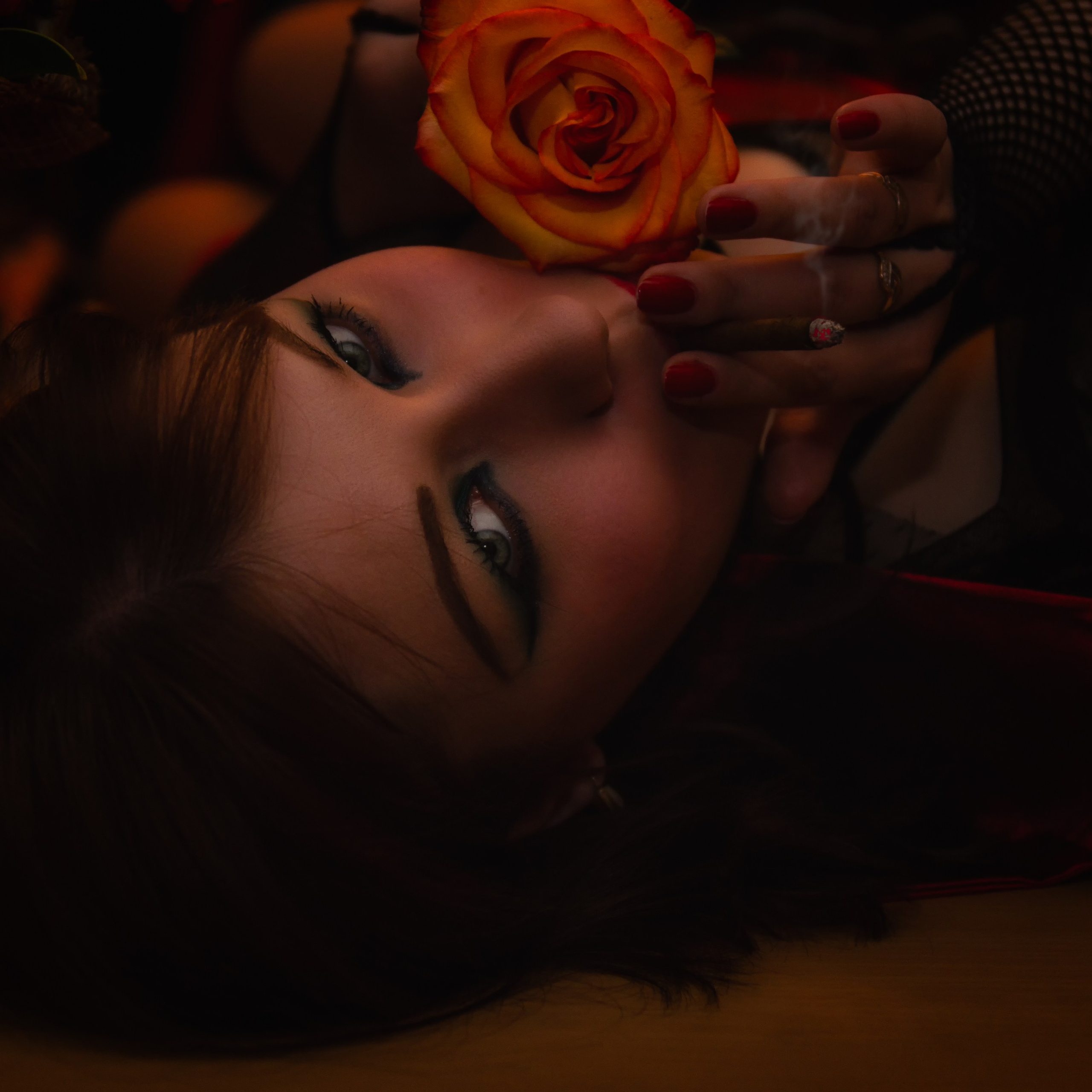 девушка лежит с сигаретой и цветками