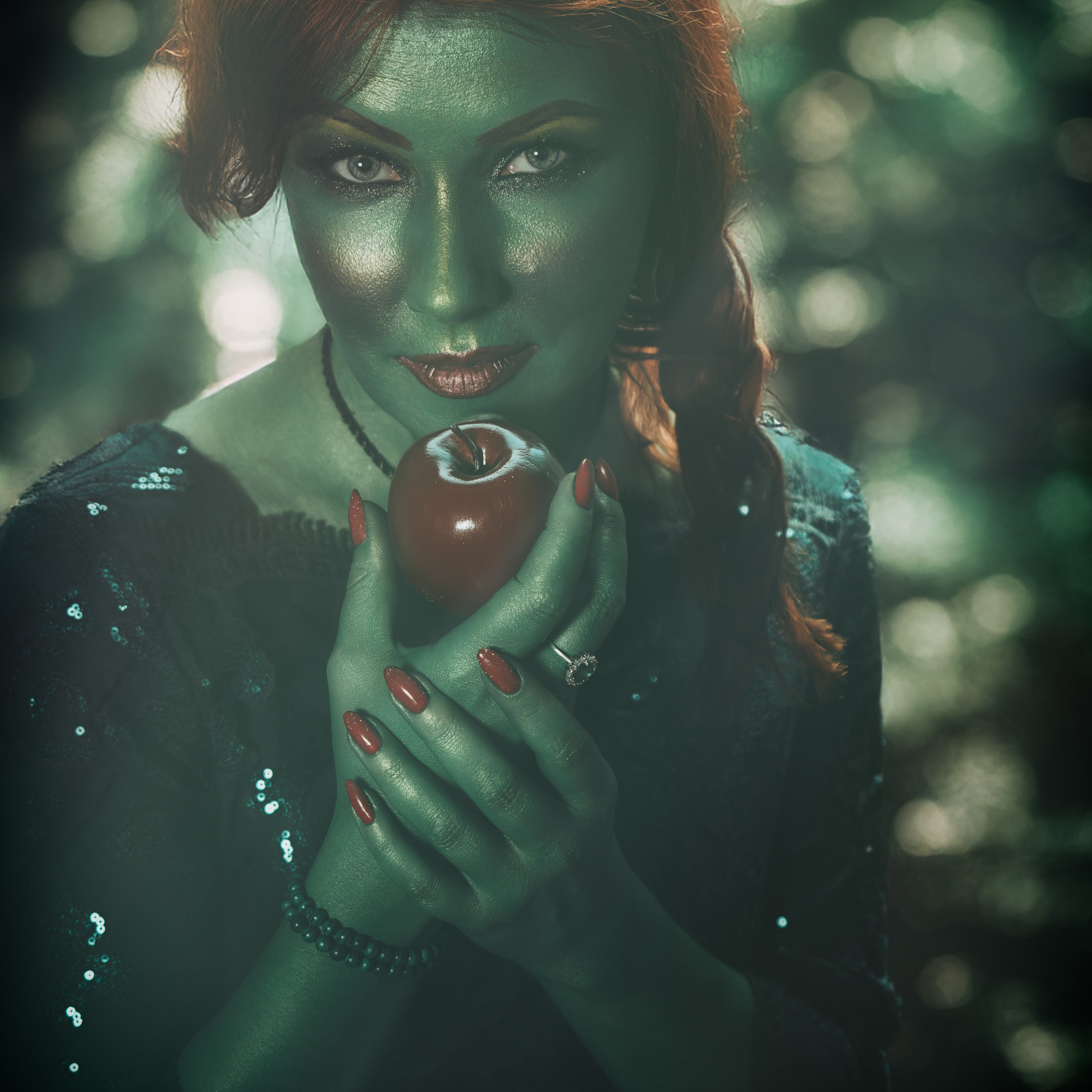 Рыжеволосая зеленокожая девушка хочет съесть яблоко