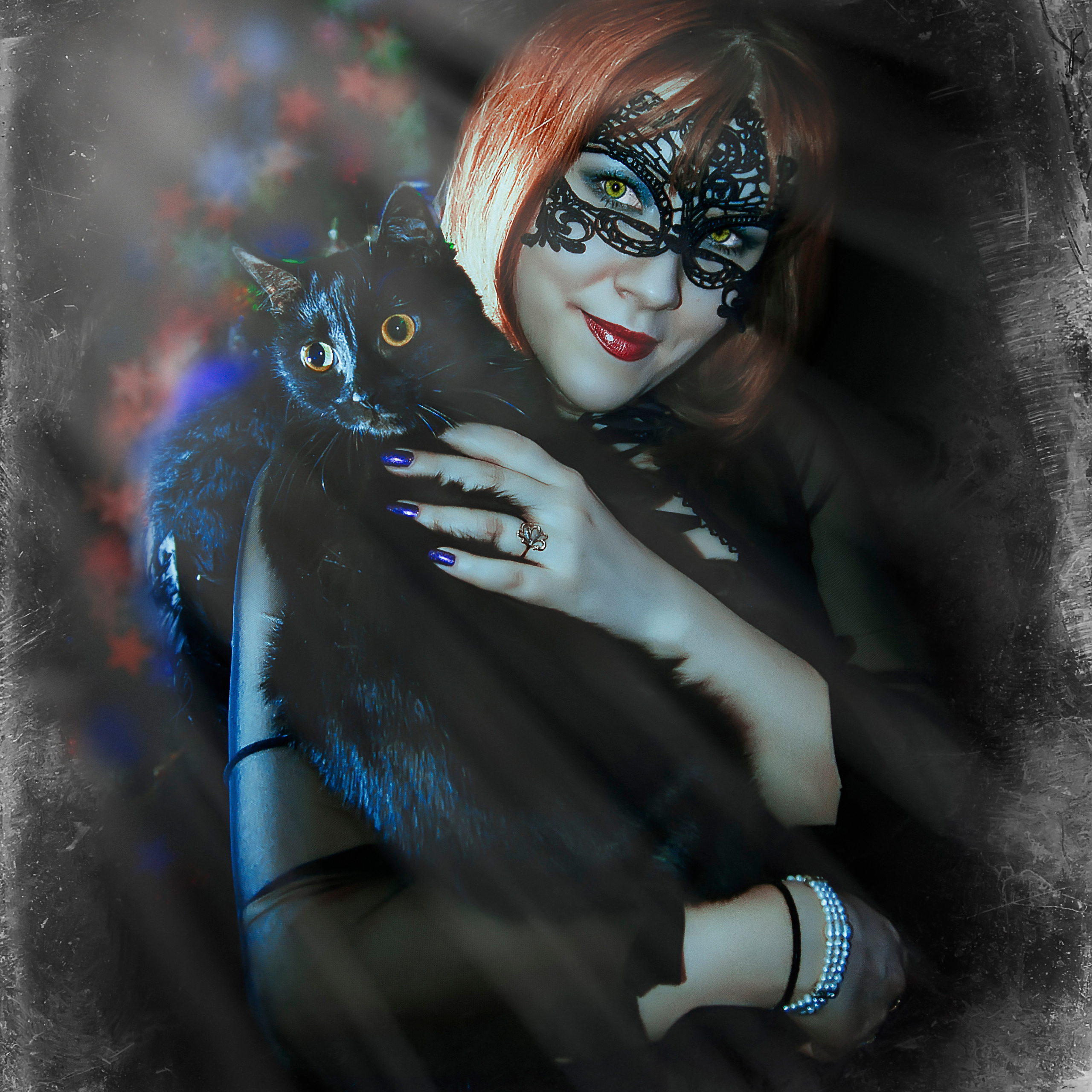 Девушка в маскарадной маске с черной кошкой на руках