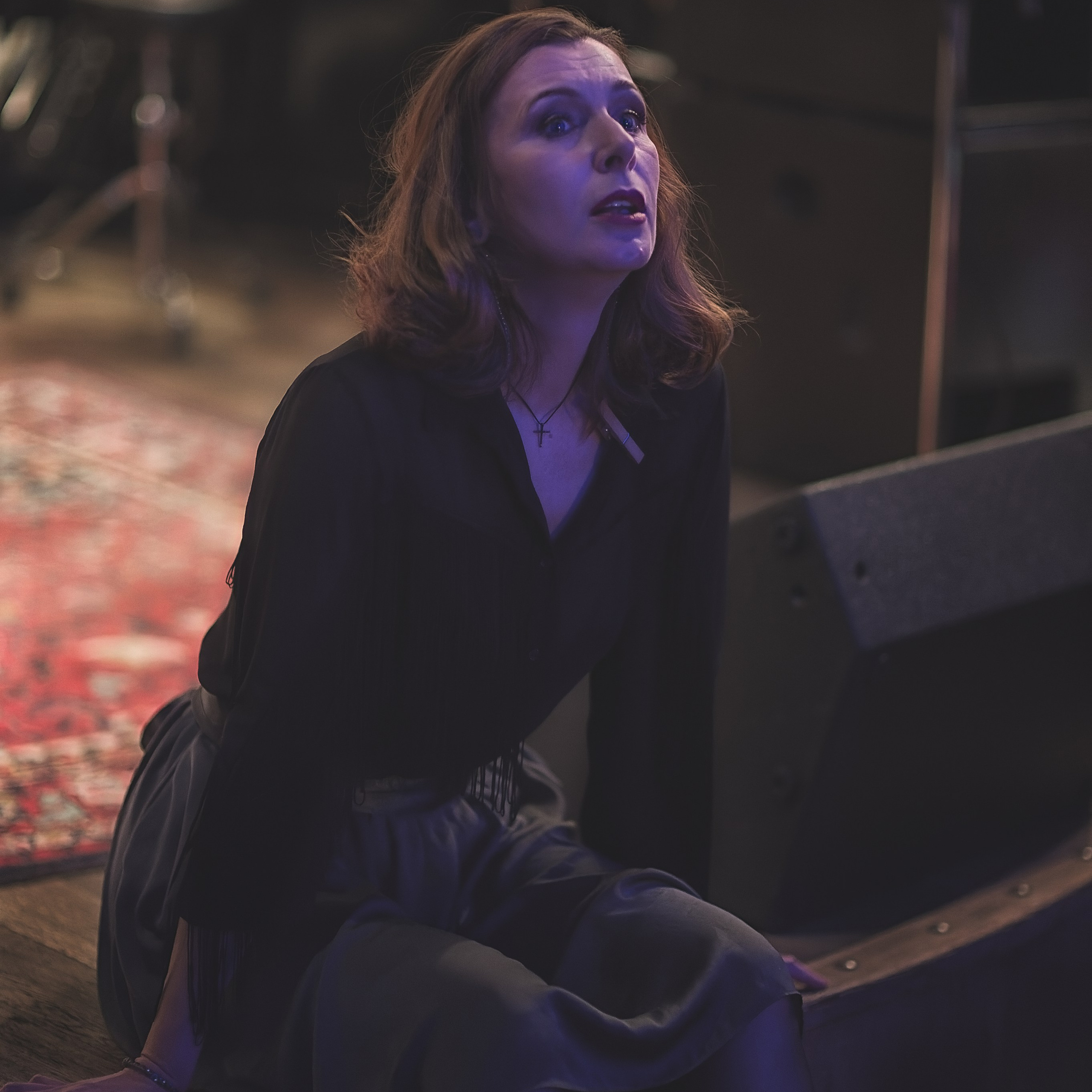 Девушка сидит на краю сцены