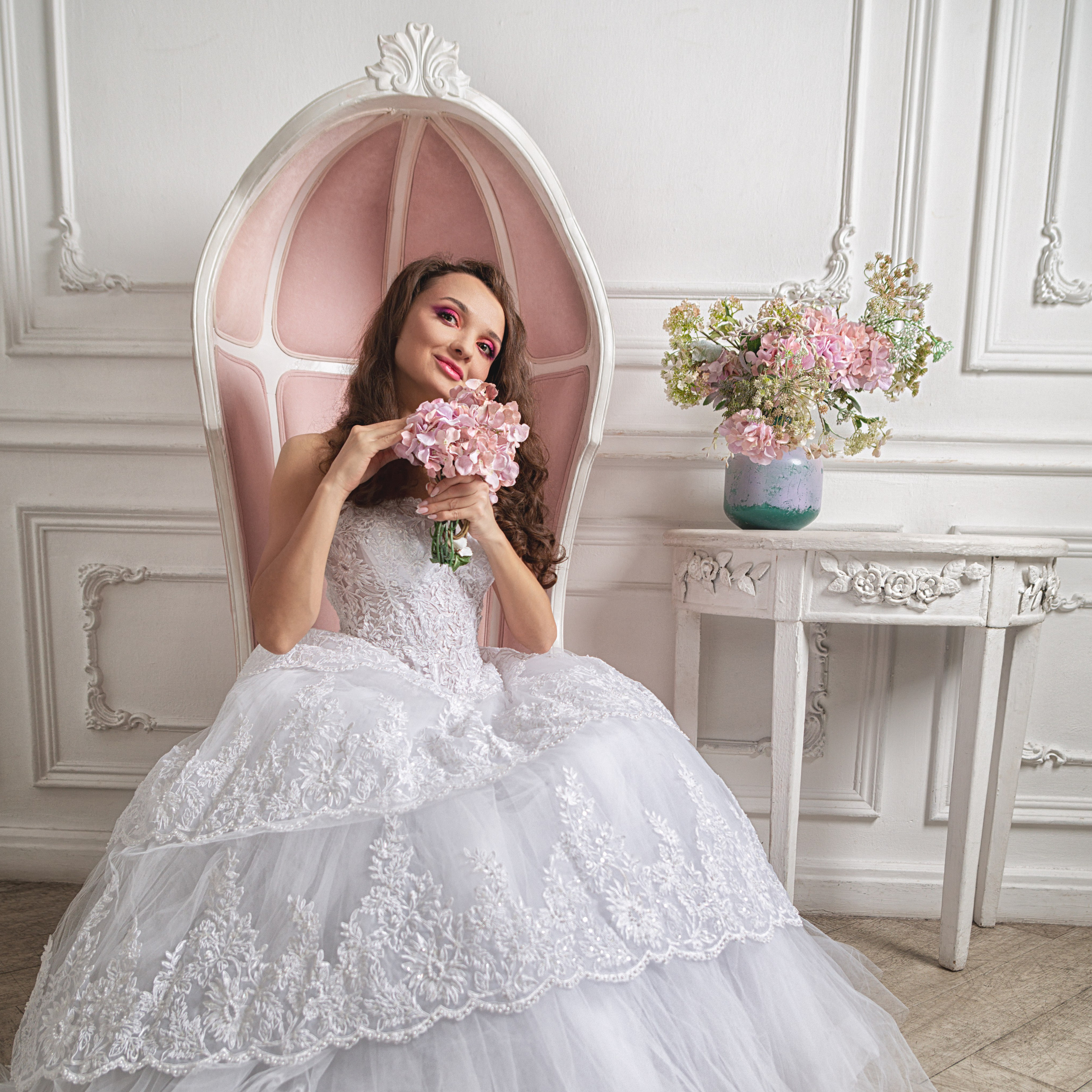 Невеста сидит в кресле с букетом цветов