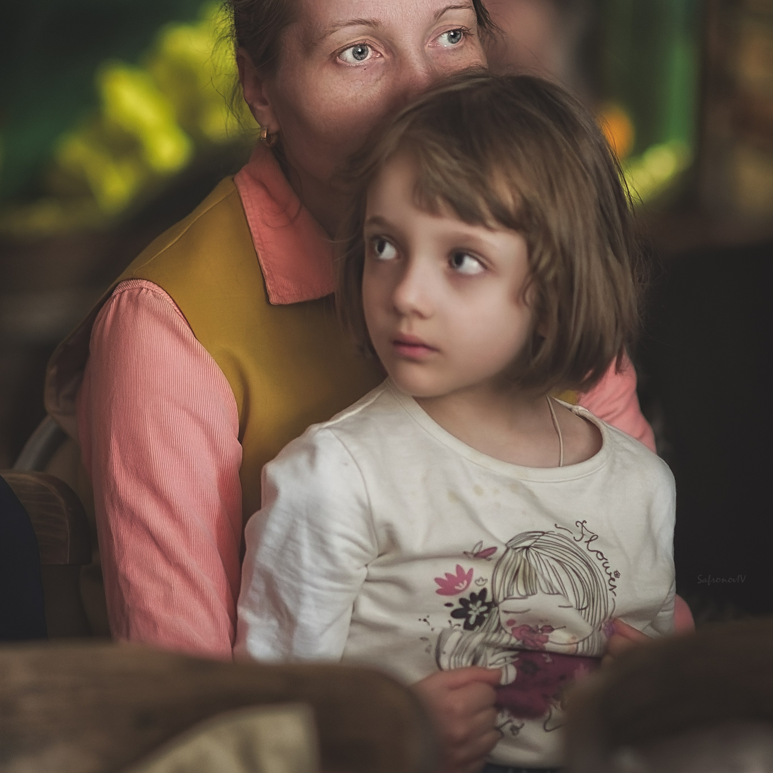 Мама держит ребенка на руках. Ребенок смотрит в сторону