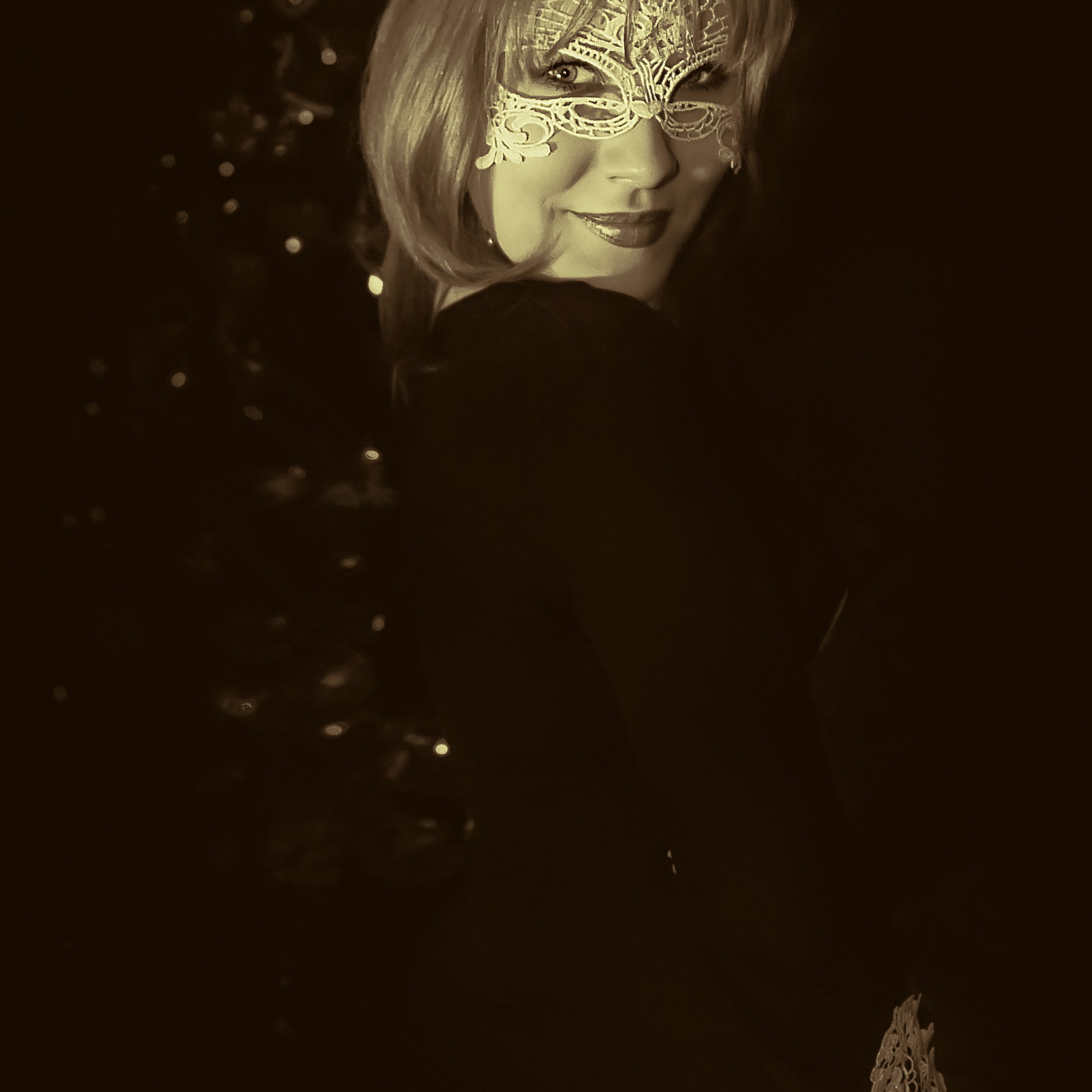 Девушка в шляпе и маске оборачивается через плечо и ехидно улыбается