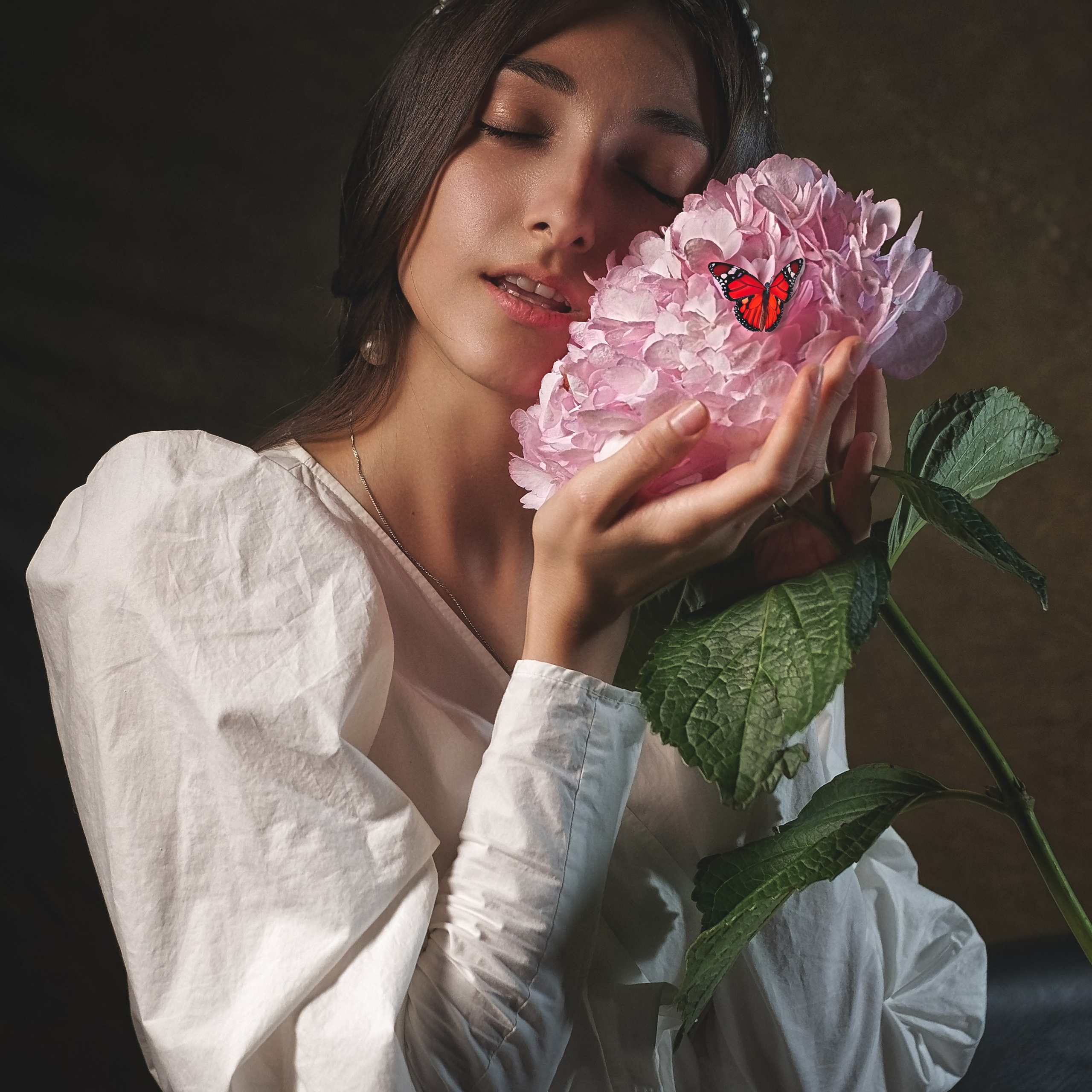 Девушка держит огромный цветок с бабочкой