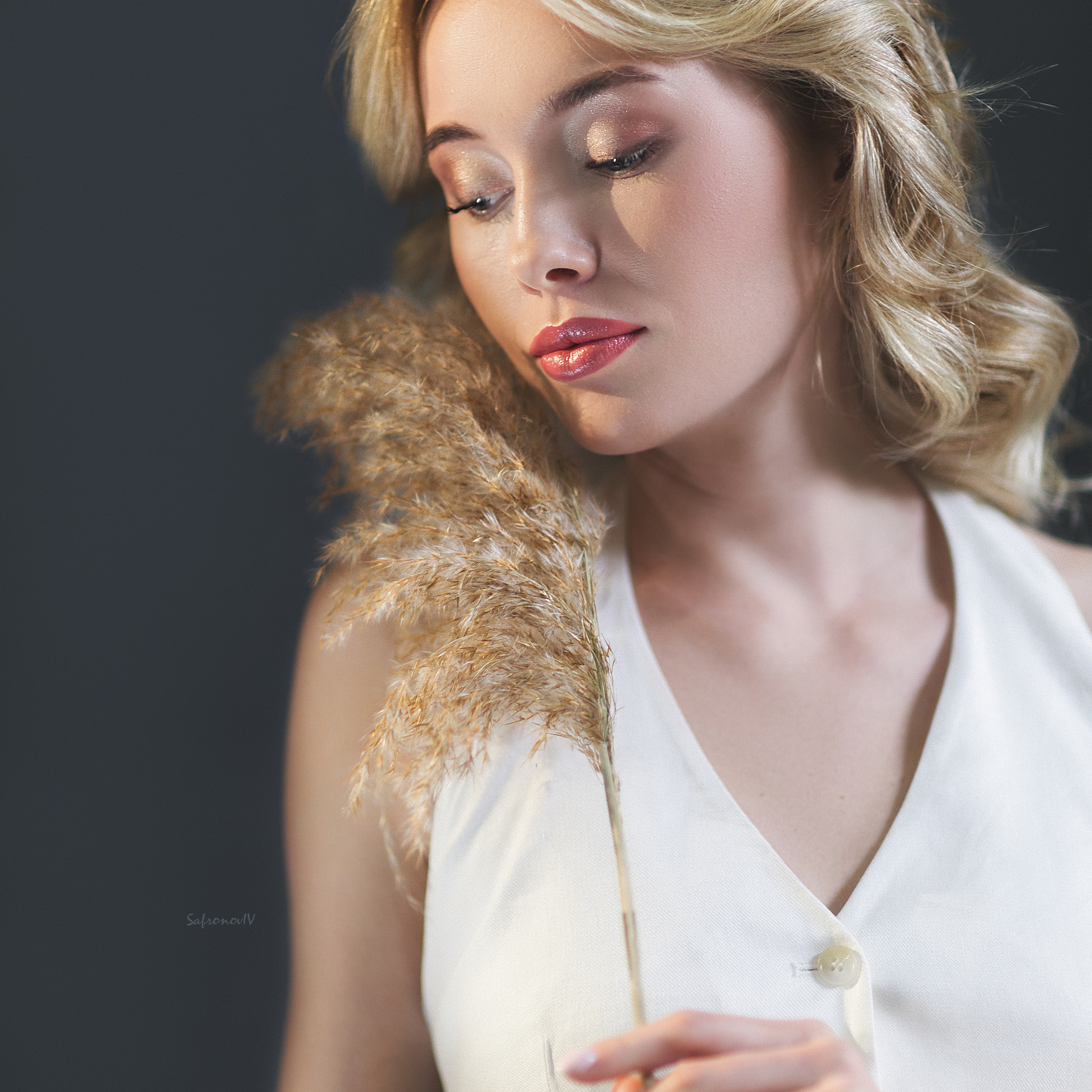 Блондинка нежно держит растение