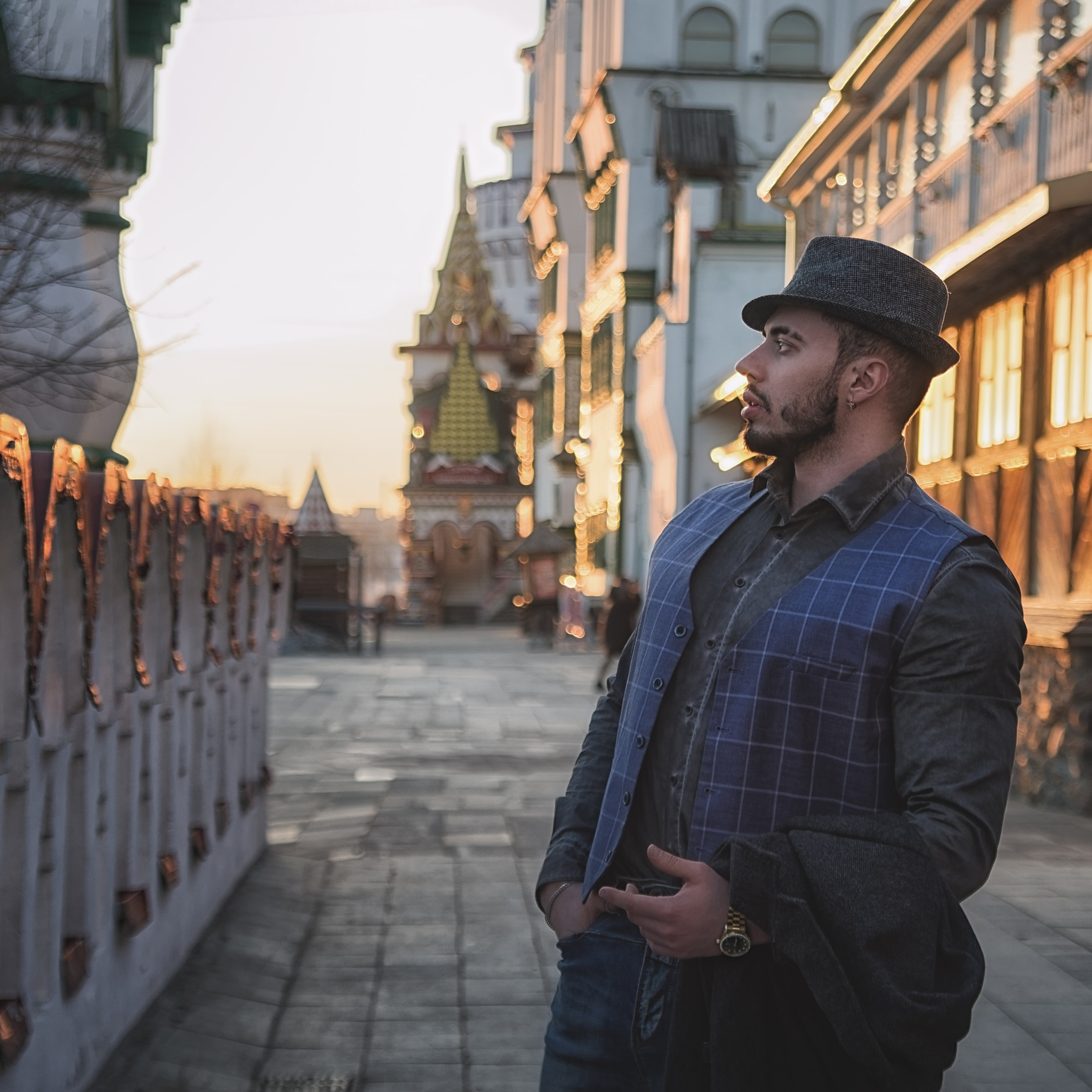 Мужчина стоит на закате, держит пальто в руках