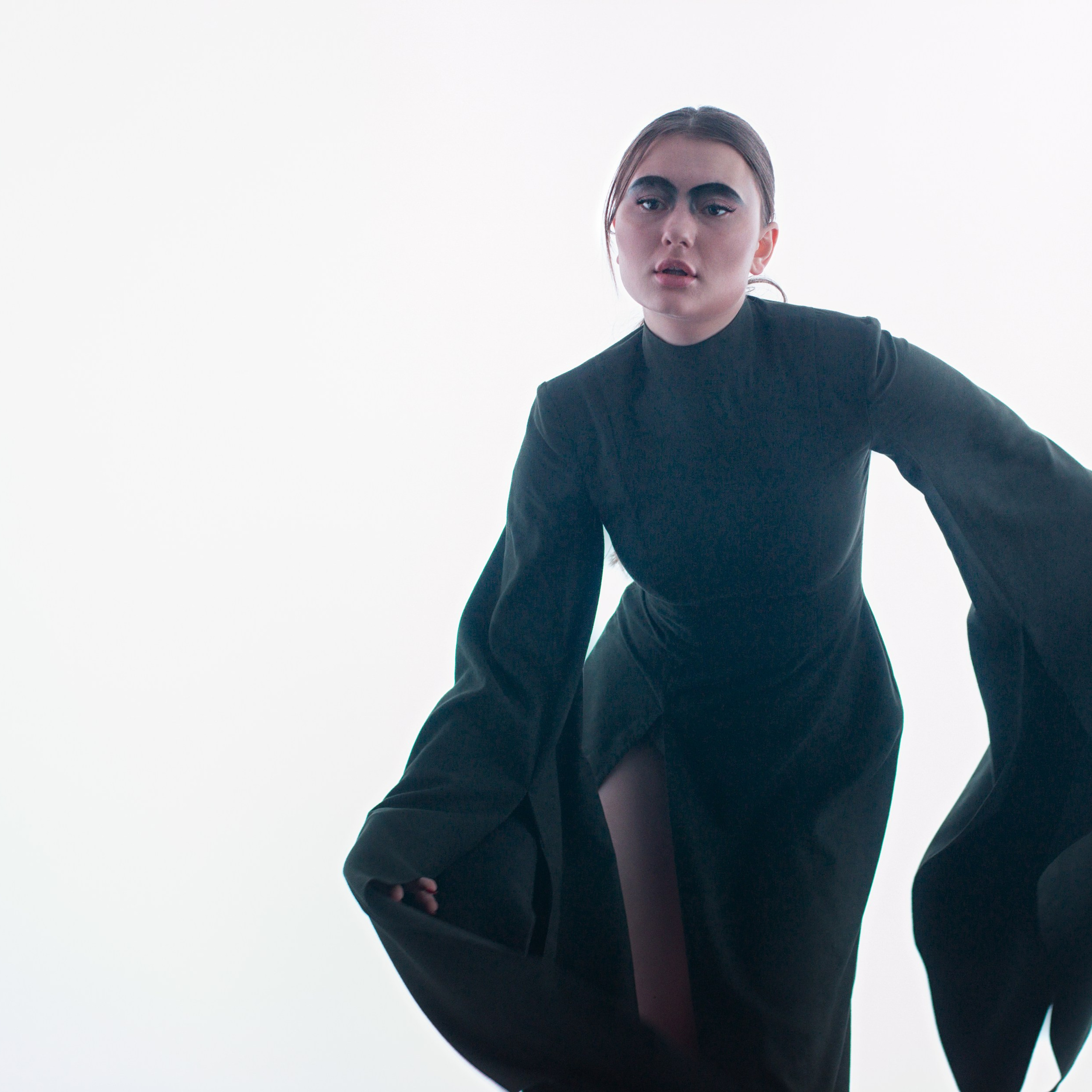 Девушка на белом фоне в платье с длинными рукавами