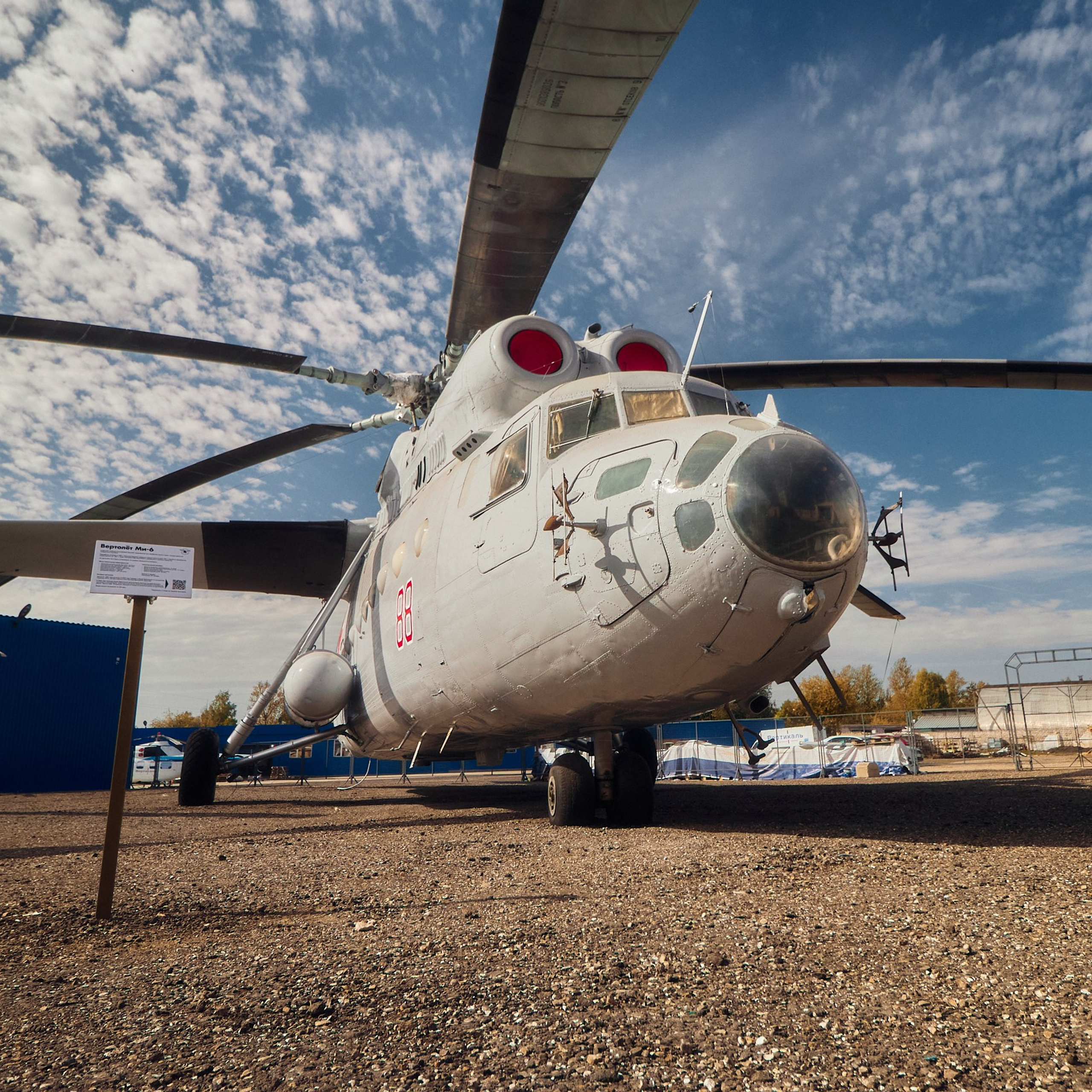 Вертолёт Ми-6, экспонируемый в музее вертолётов в Торжке, на фоне ясного неба и других экспонатов