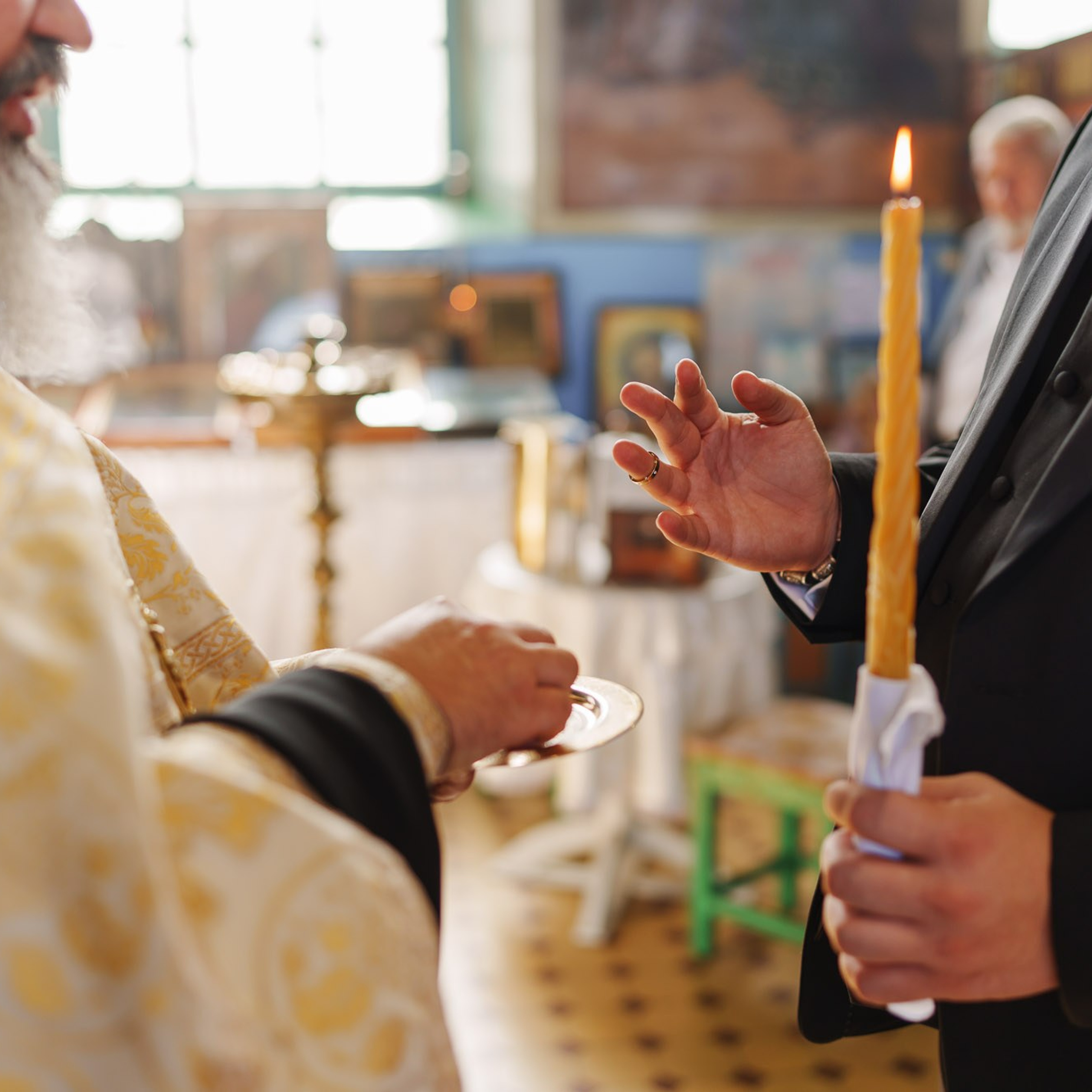 Деталь православного венчания, свеча в руках жениха и венчальное блюдо