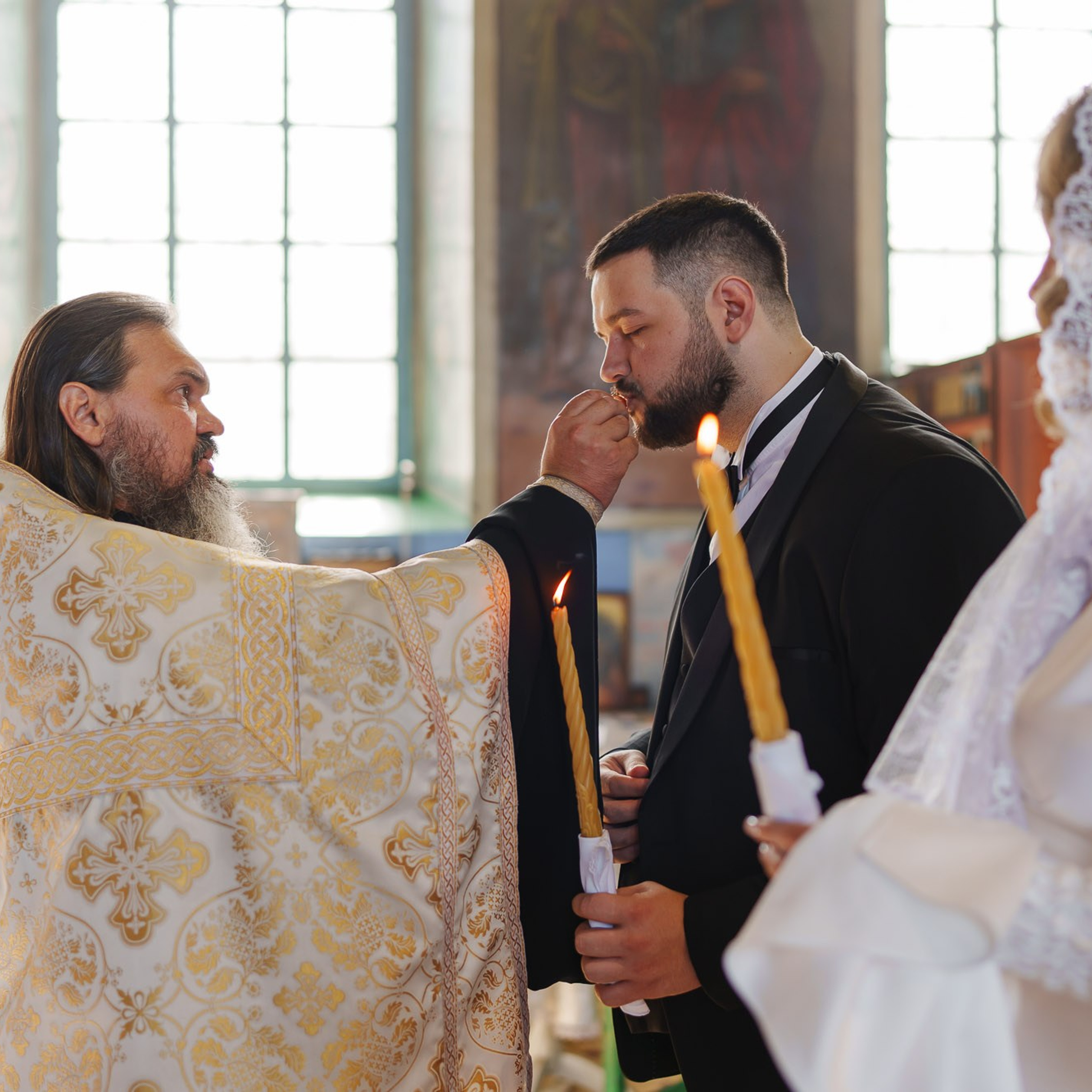 Причащение жениха во время православного венчания в храме