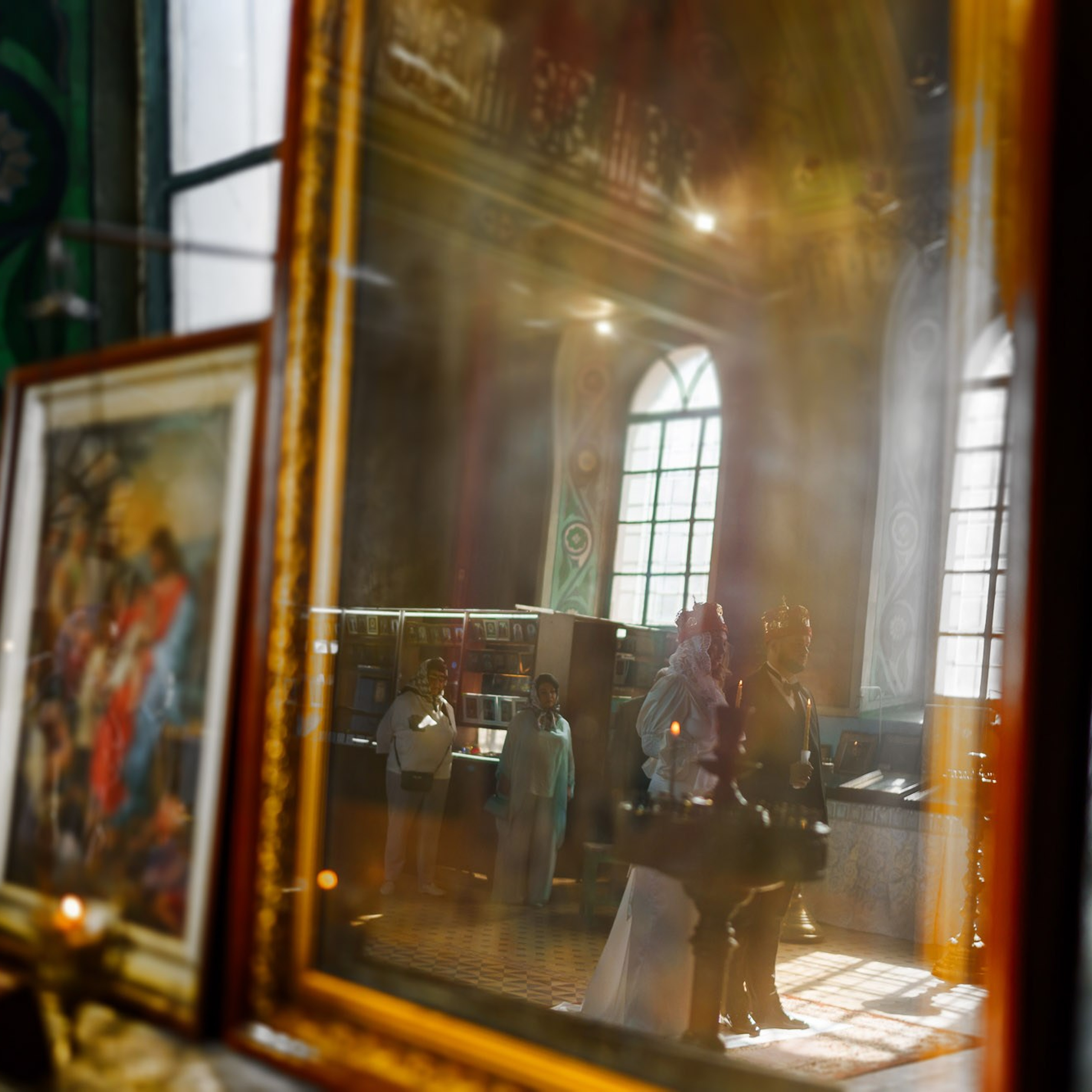 Отражение молодожёнов в венцах во время православного венчания