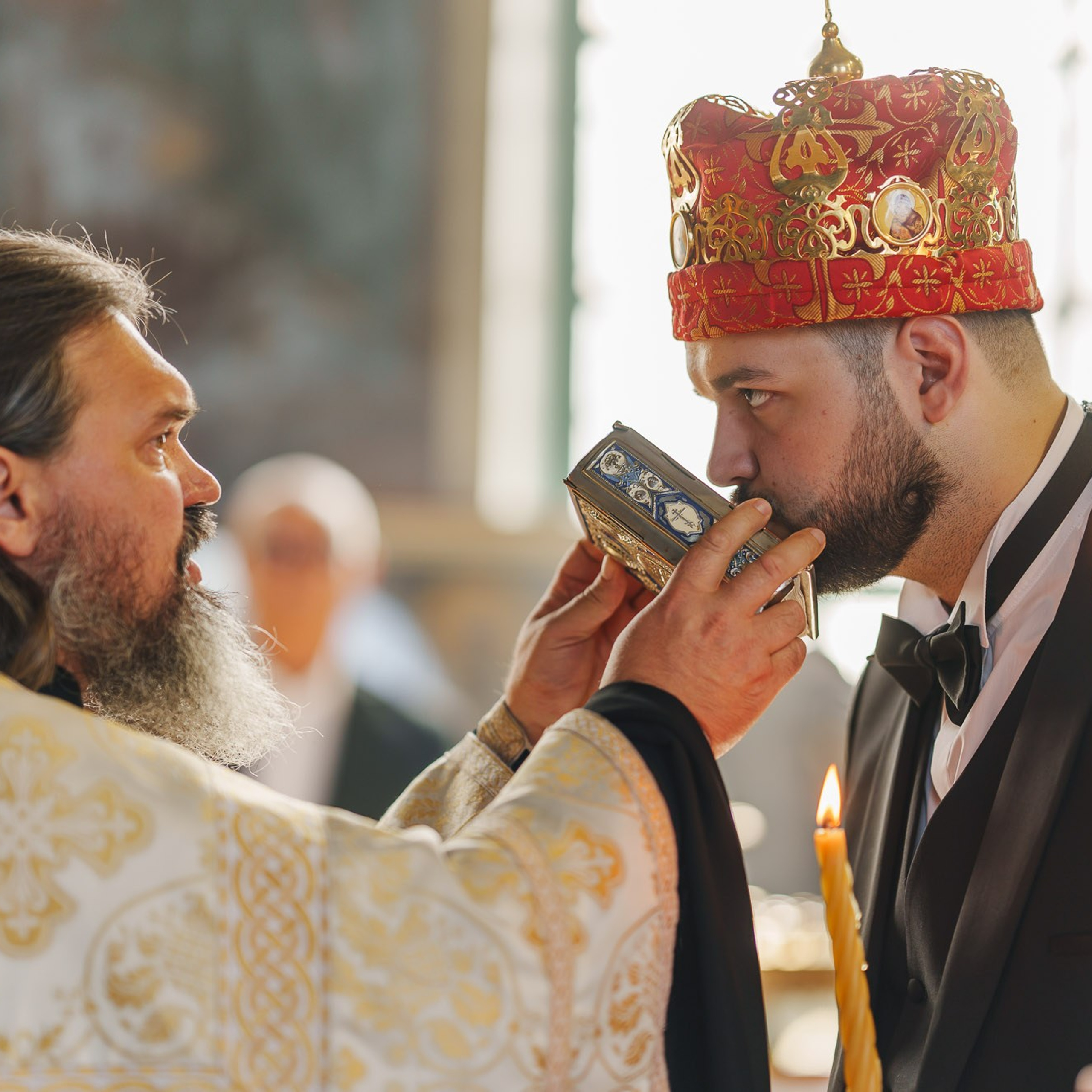 Жених целует Евангелие во время православного венчания
