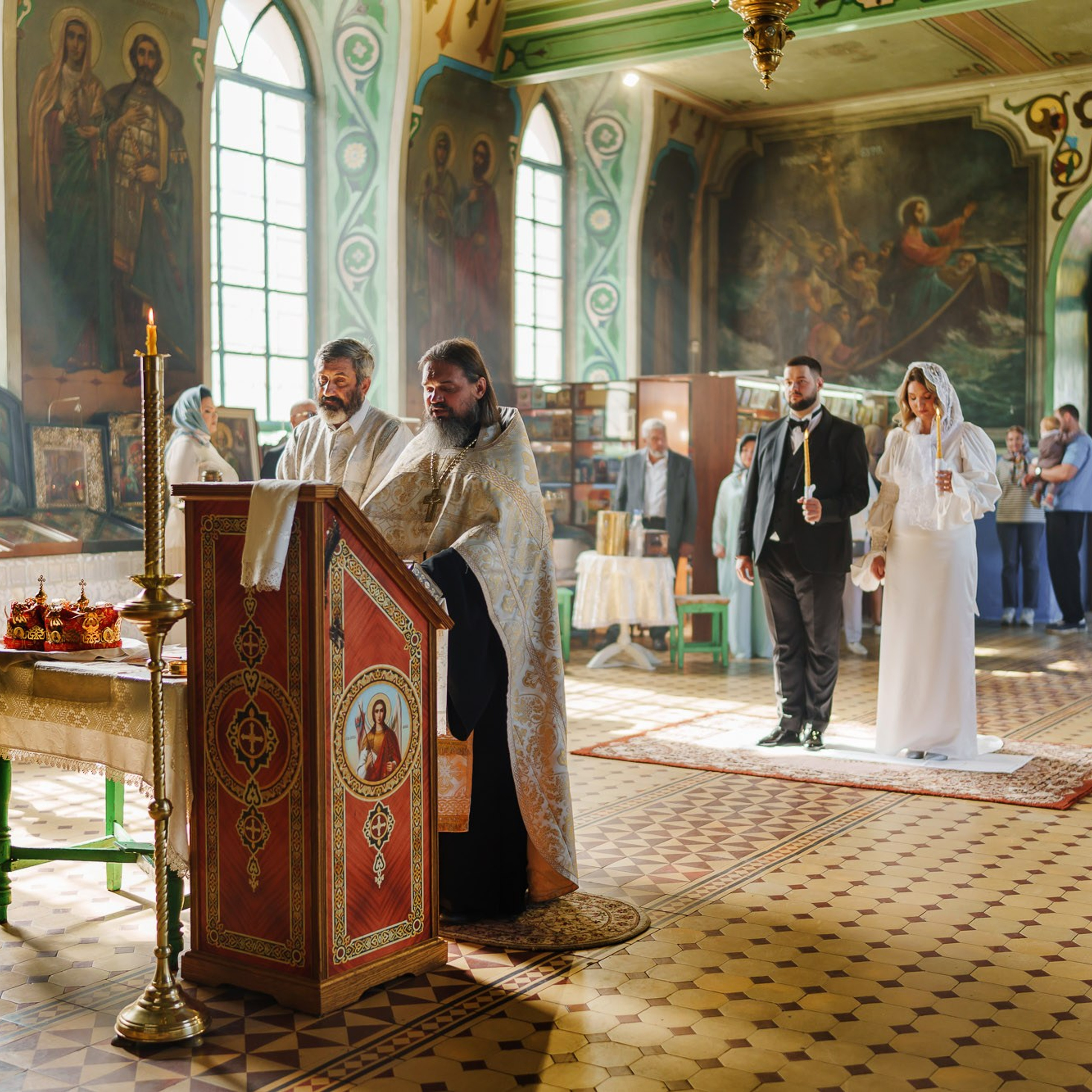 Общий вид православного венчания в храме со священником и молодожёнами