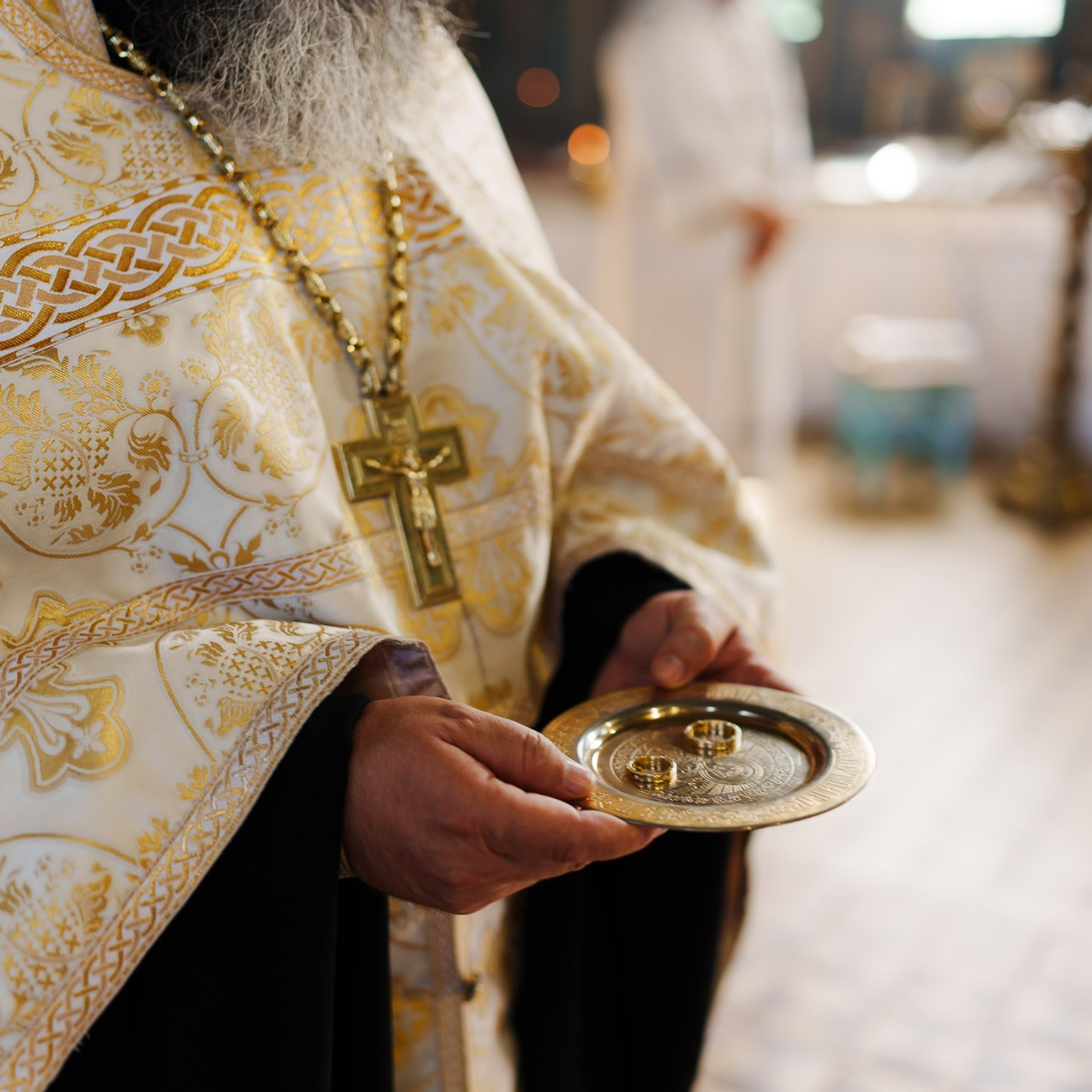 Священник с венчальными кольцами во время православного венчания