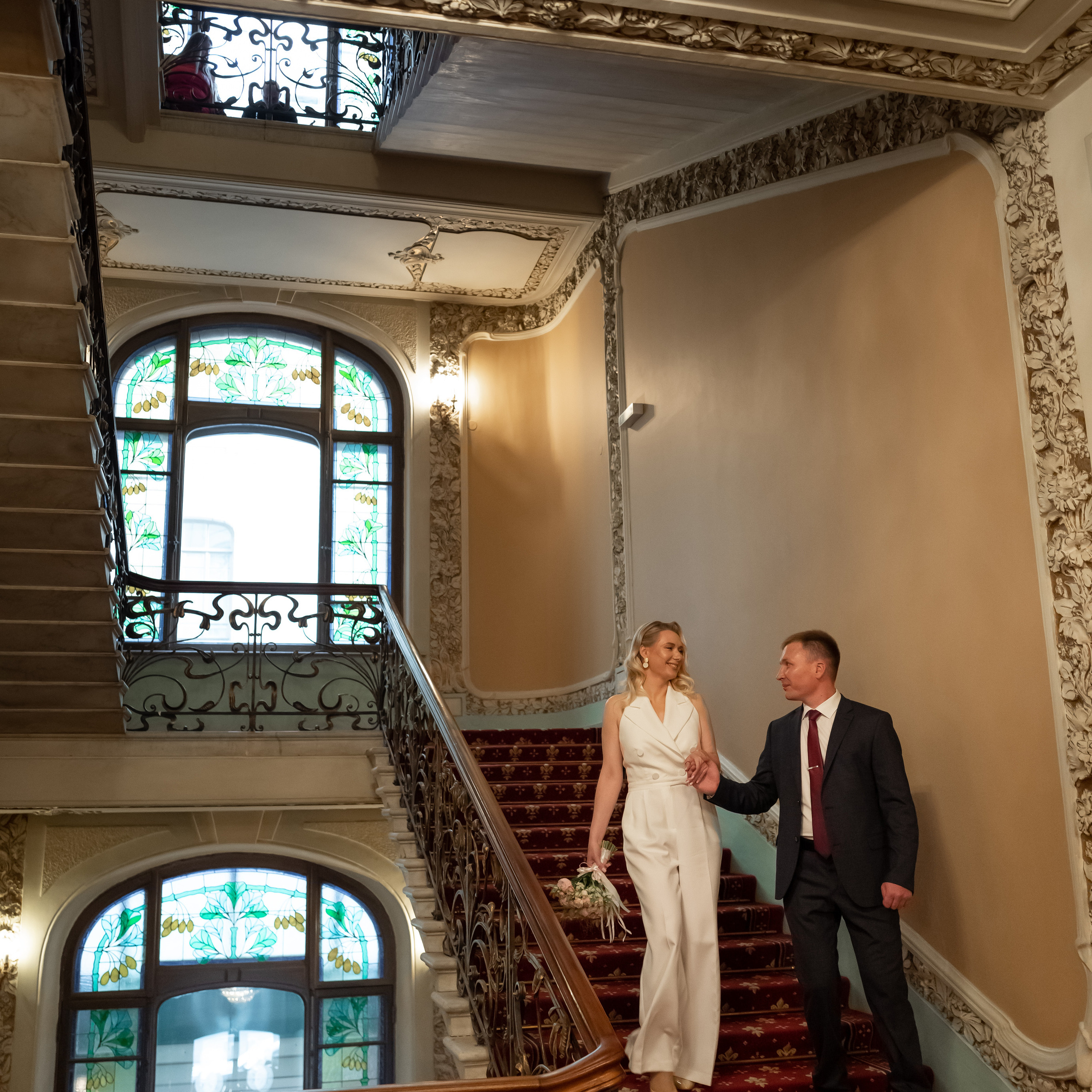 Пара идет по лестнице после регистрации брака