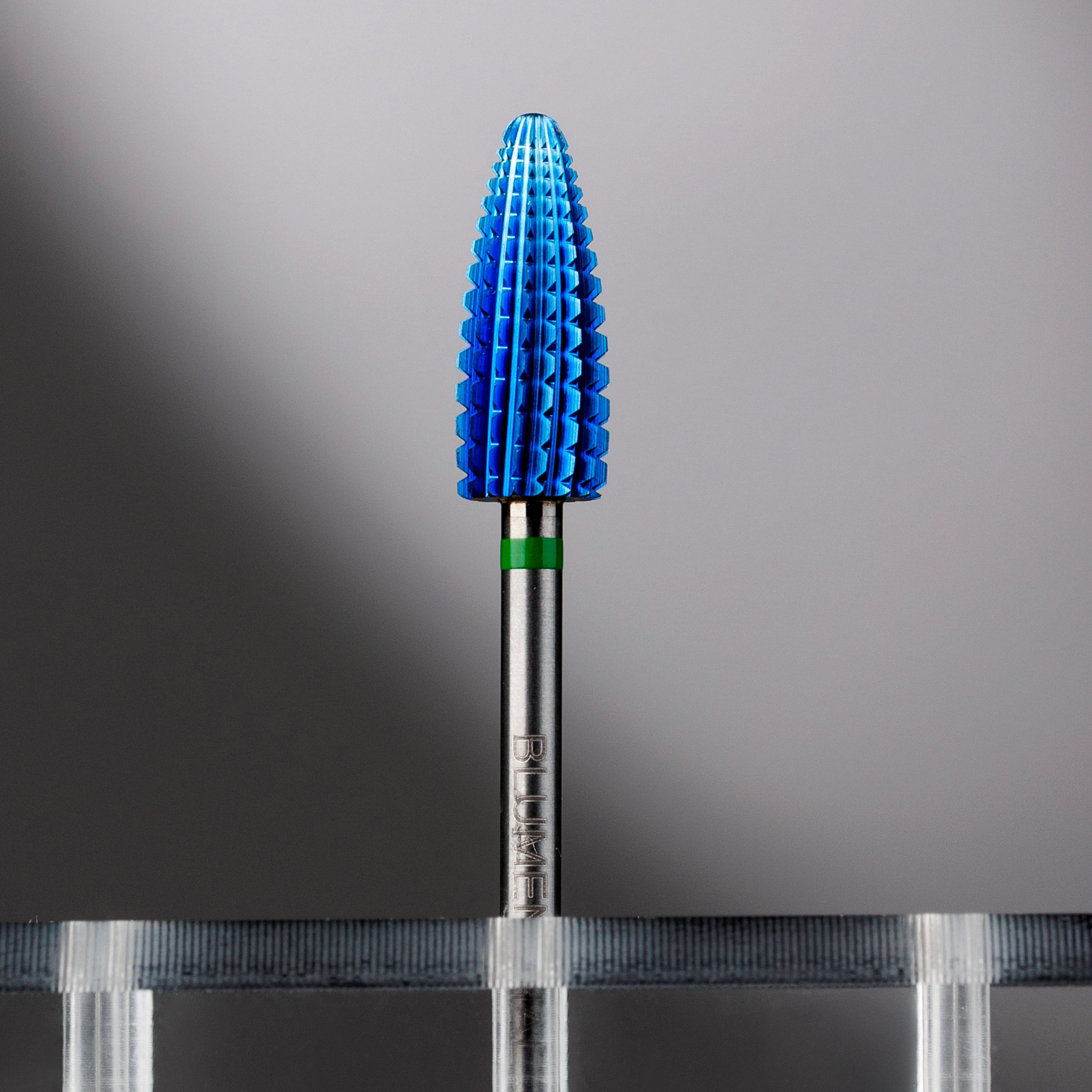 Профессиональная предметная съёмка маникюрной фрезы на тёмном фоне с подсветкой