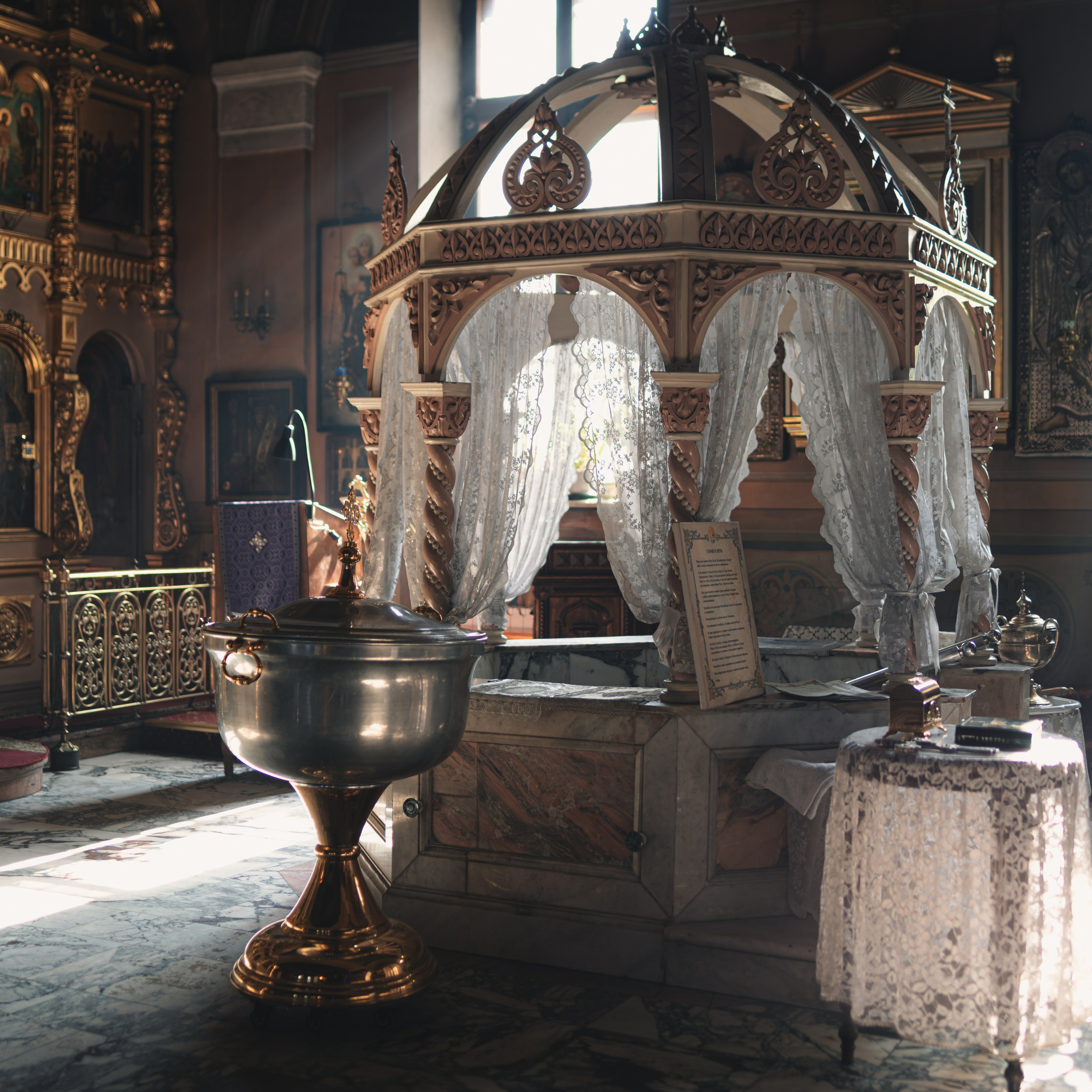 Иконостас и убранство православного храма во время Таинства Крещения ребёнка.