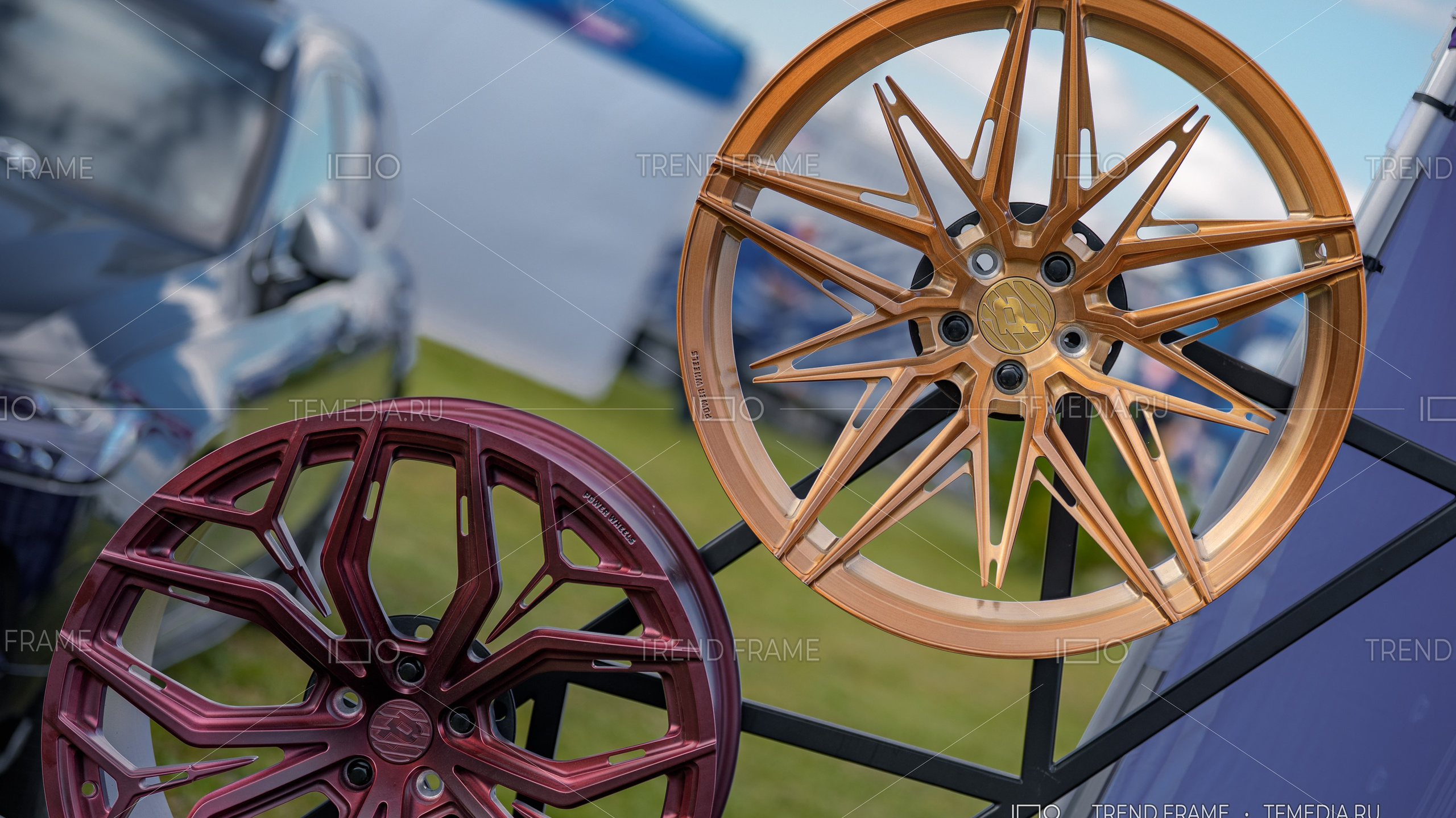 Кованые диски Power Wheels — золотистый многоспицевой и бордовый геометрический дизайн, предметная съёмка на выставке, Москва