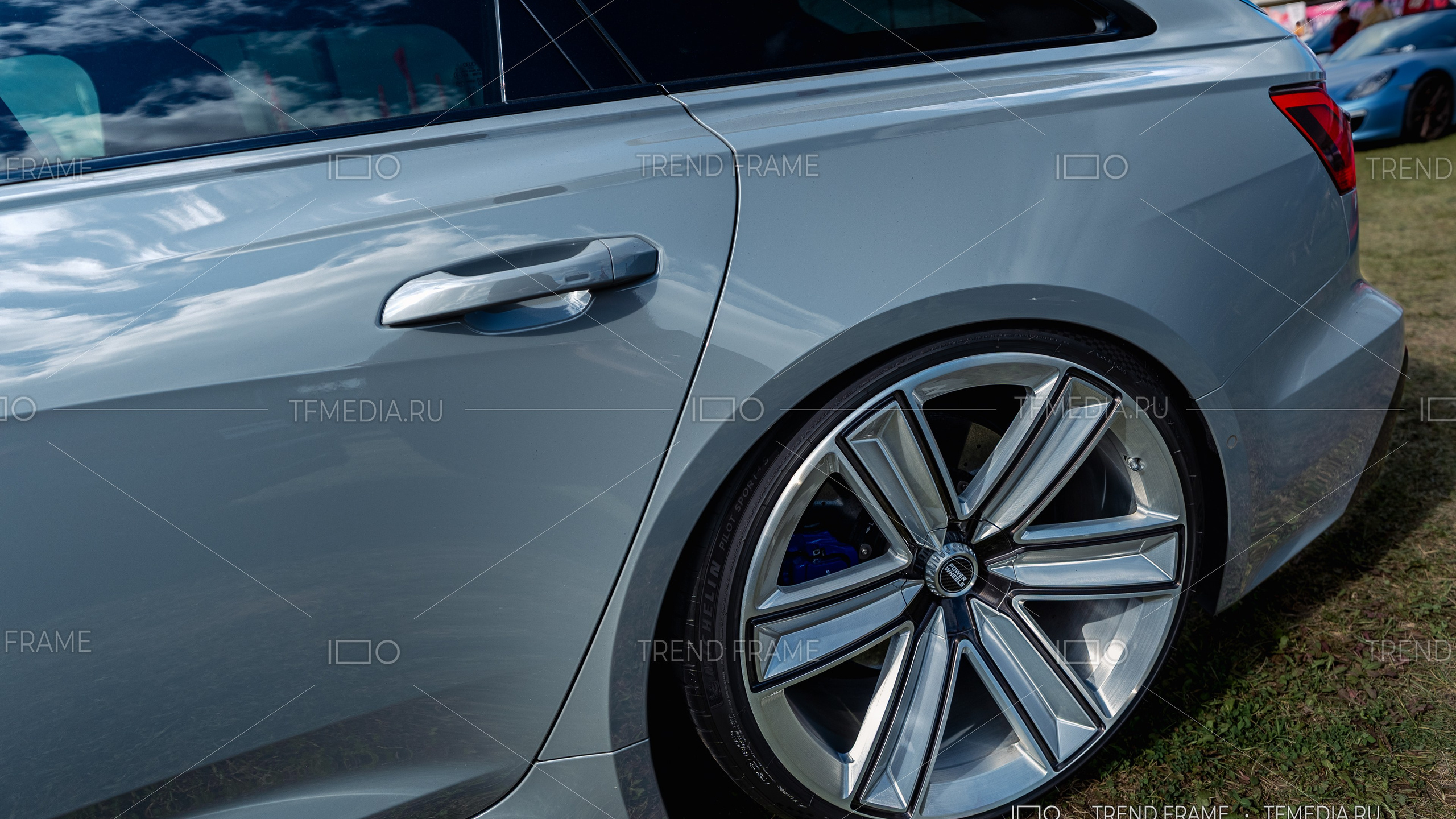 Кованый диск Power Wheels на Audi — серебристый кузов, хромированные широкие спицы, задний боковой ракурс с синим суппортом, премиальная съёмка Москва