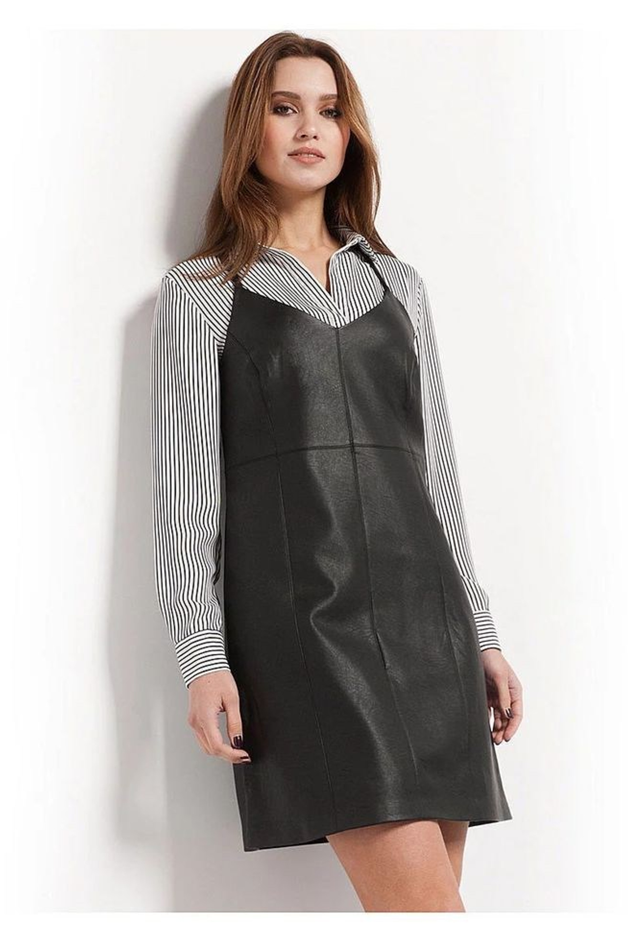 Предметная съемка кожаного сарафана на модели на нейтральном фоне для фокусировки на форме и блеске