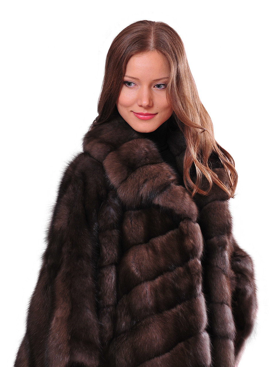 Модель в шубе на белом фоне.