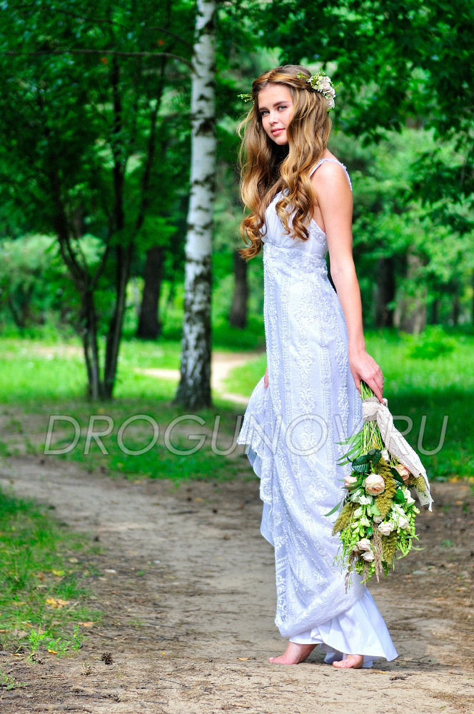 модель со свадебным букетом в платье бохо на фоне леса