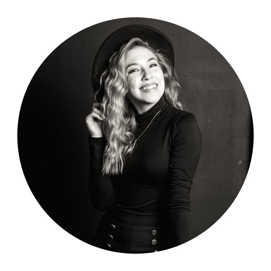 Девушка в чёрной шляпе улыбается