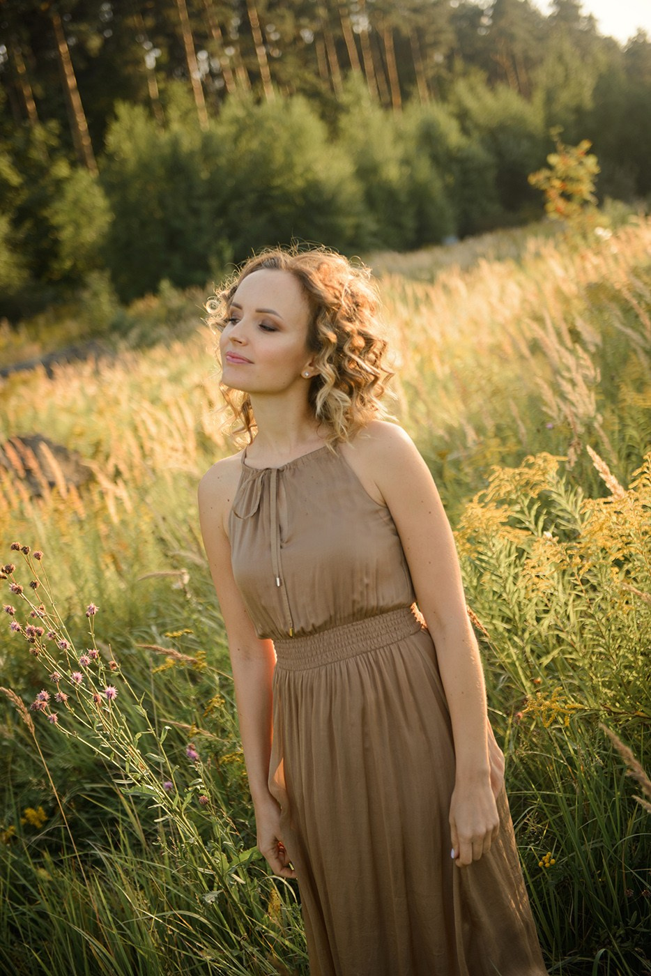 A photo shoot for a woman l in the field. Sunset photo shoot for a girl Curly hair style. (photographer in Edinburgh Elena)