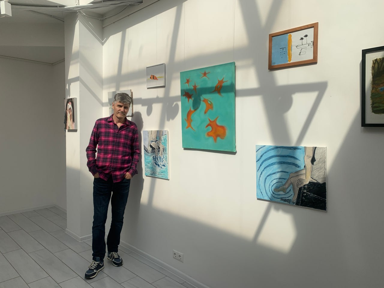 Олег Семеновых на фоне экспозиции "Ближе к воде", галерея Arbuzz