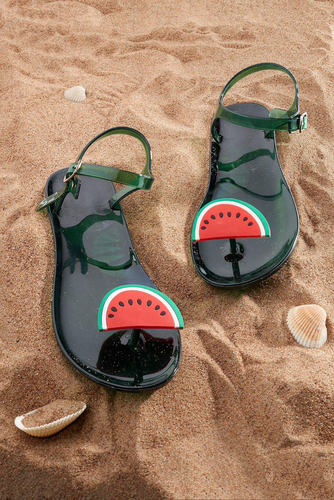 Пляжные сандалии лежат на песке - студийная имиджевая съёмка